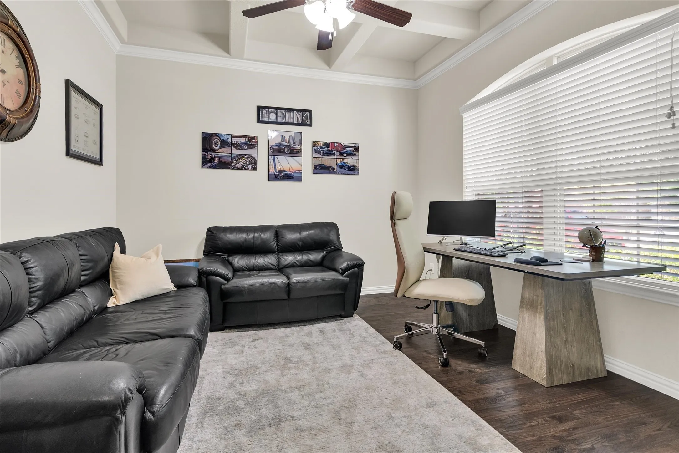 Coffer ceiling with crown molding, wood-finish flooring, and a large arched window with horizontal blinds