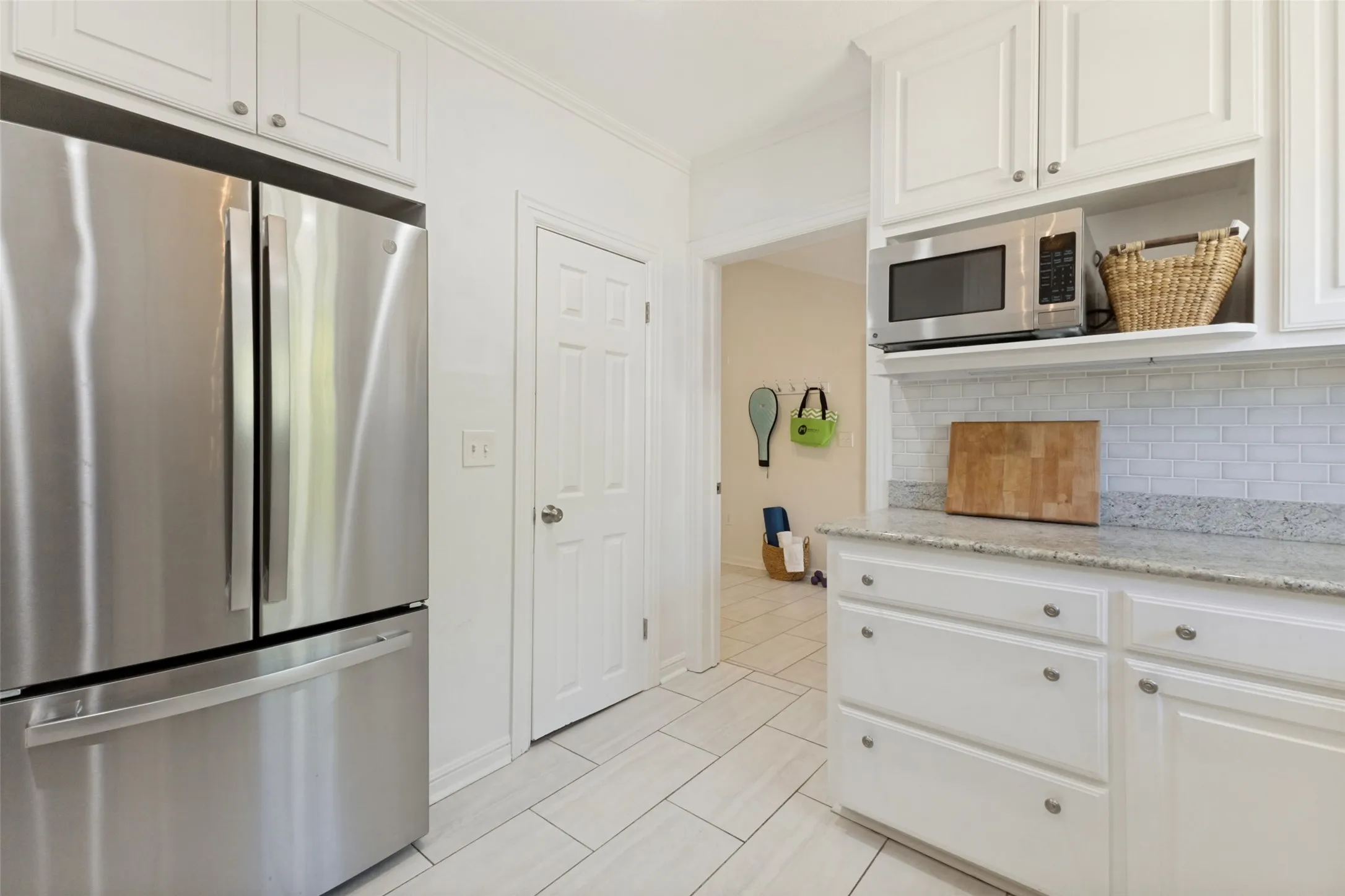 Walk-in pantry to the right of the refrigerator/freezer, and the laundry room and garage just beyond.