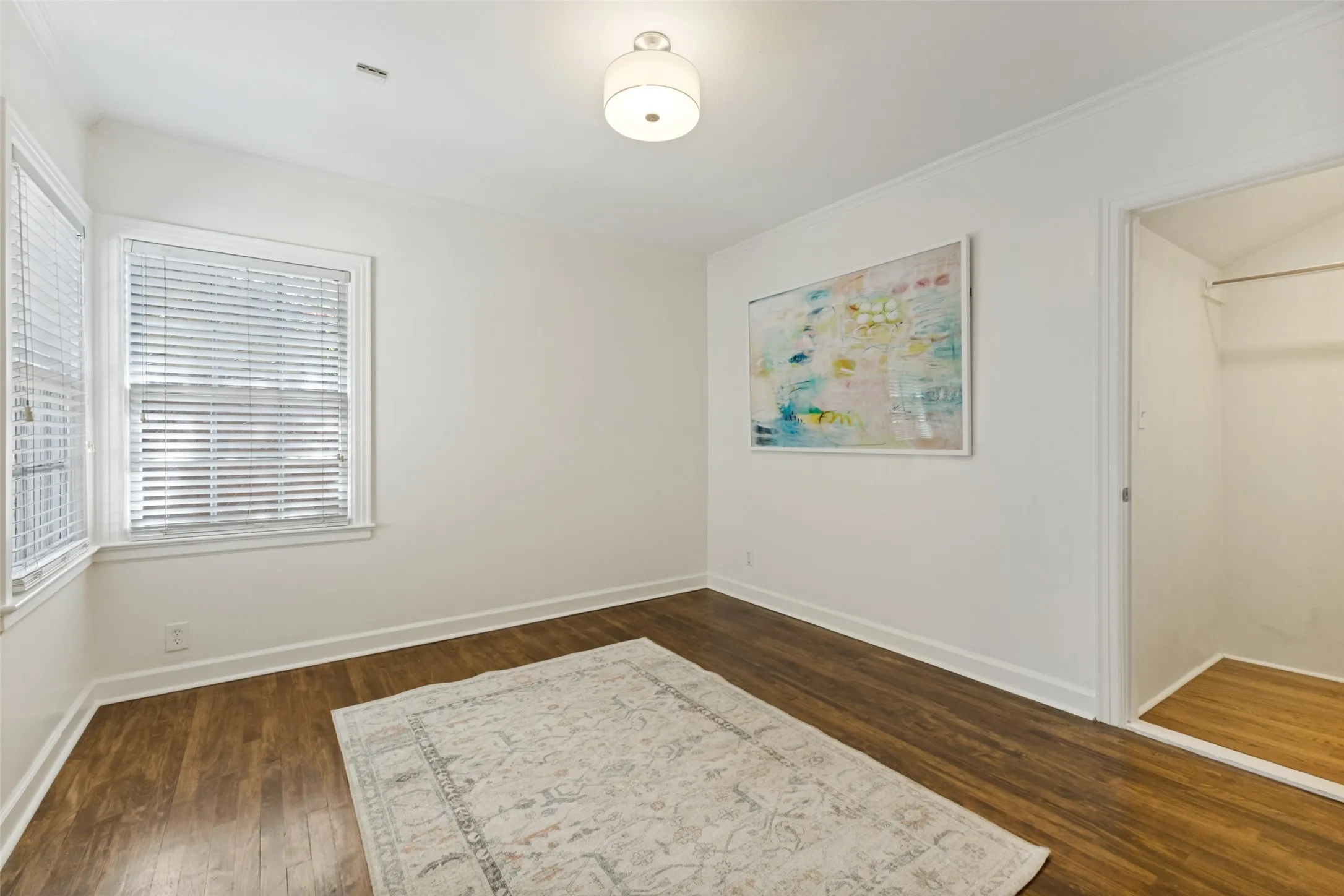 Gleaming hardwood floors and natural light fill this room, along with a walk-in closet on the right. This could be a perfect nursery or guest bedroom with an adjacent full bathroom.