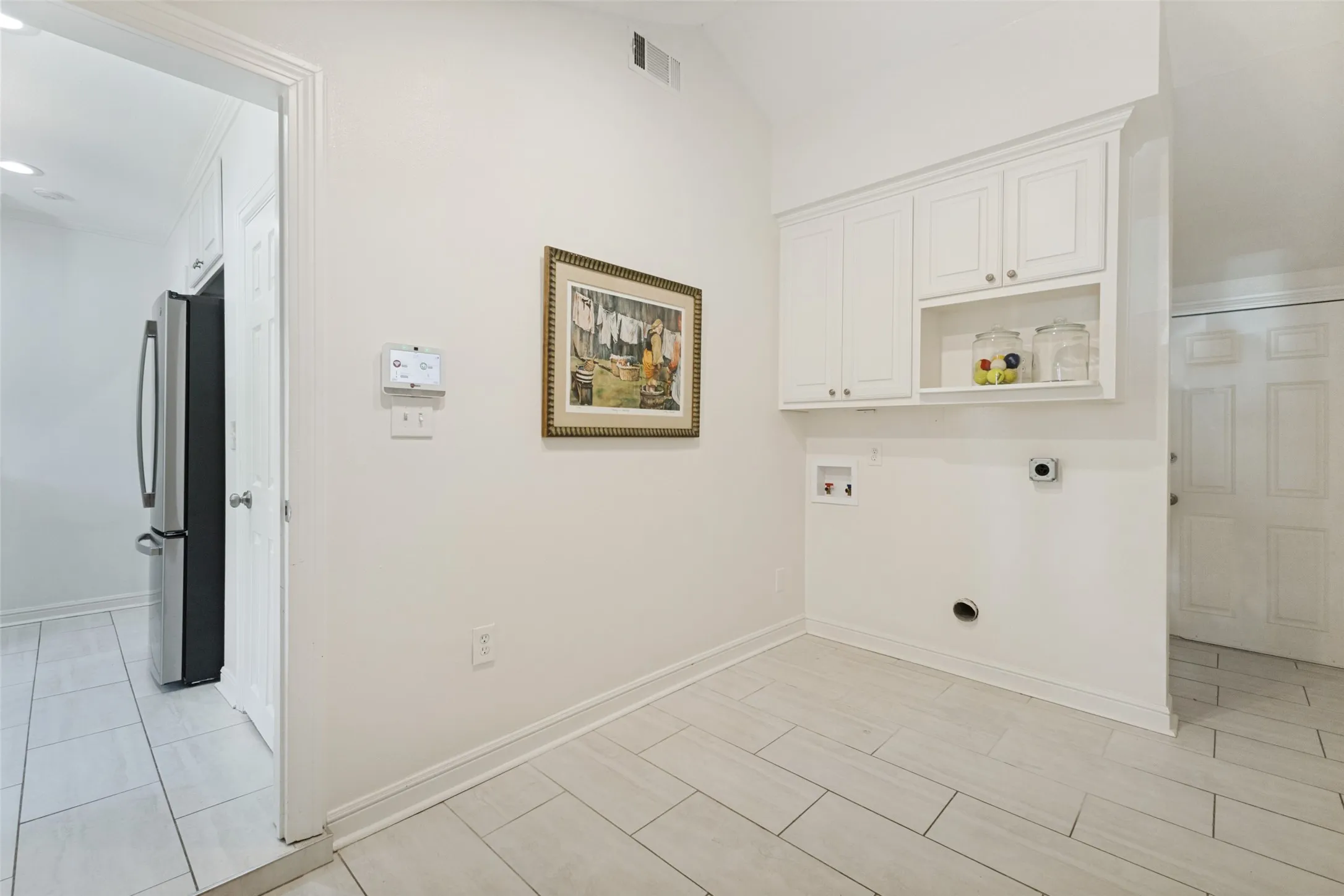 The generously sized laundry room provides space for an exercise bike or a yoga mat if multitasking is your thing. The door to the right leads to the backyard deck.