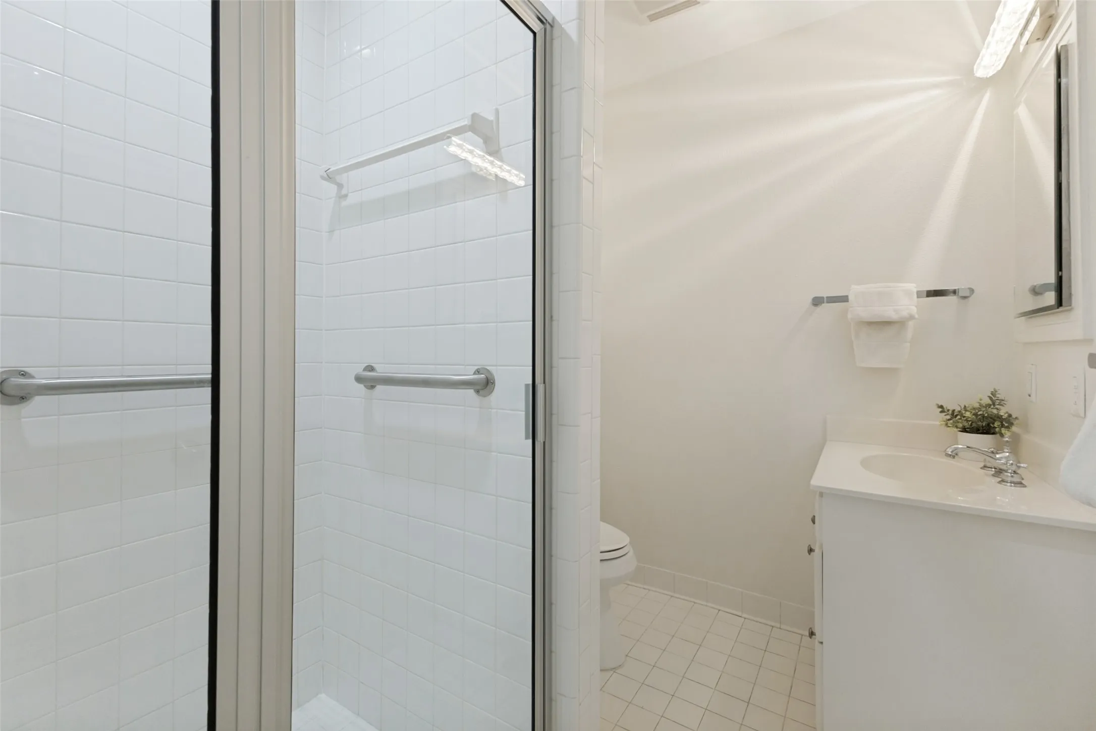 A walk-in shower is featured in this hall bath, conveniently located near the kitchen and secondary bedrooms.