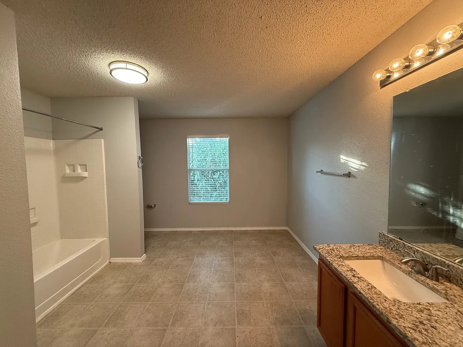 Vanity with integrated sink, granite-style countertop, and wood-finish cabinetry