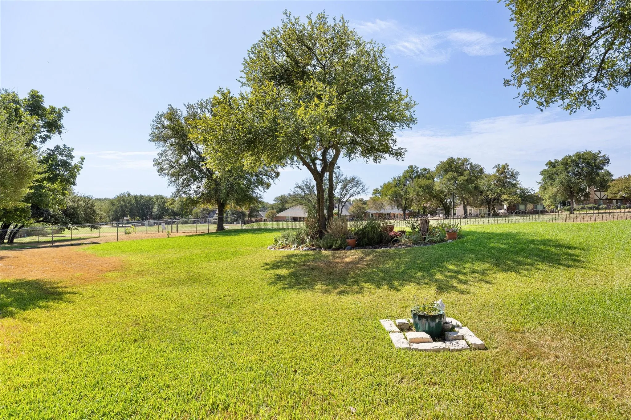 Watch the golfers and enjoy this low maintenance back yard with mature trees