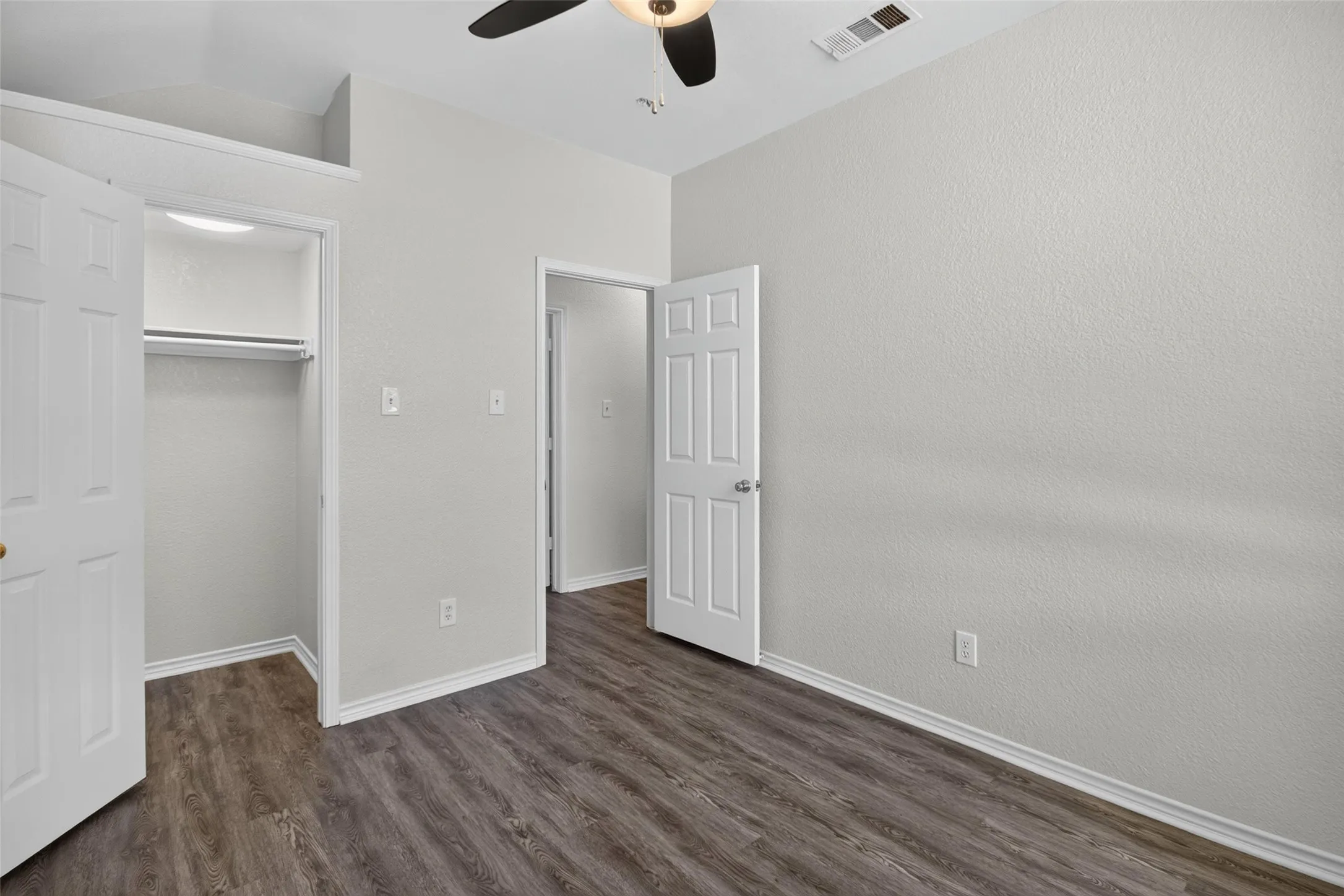 Wood-finish flooring, white trim, recessed lighting, ceiling fan, and built-in closet with hanging rod