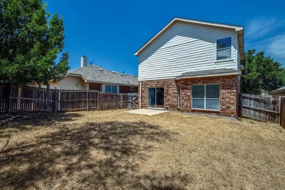 Exterior featuring brick and siding finishes, a patio area, and a fenced backyard
