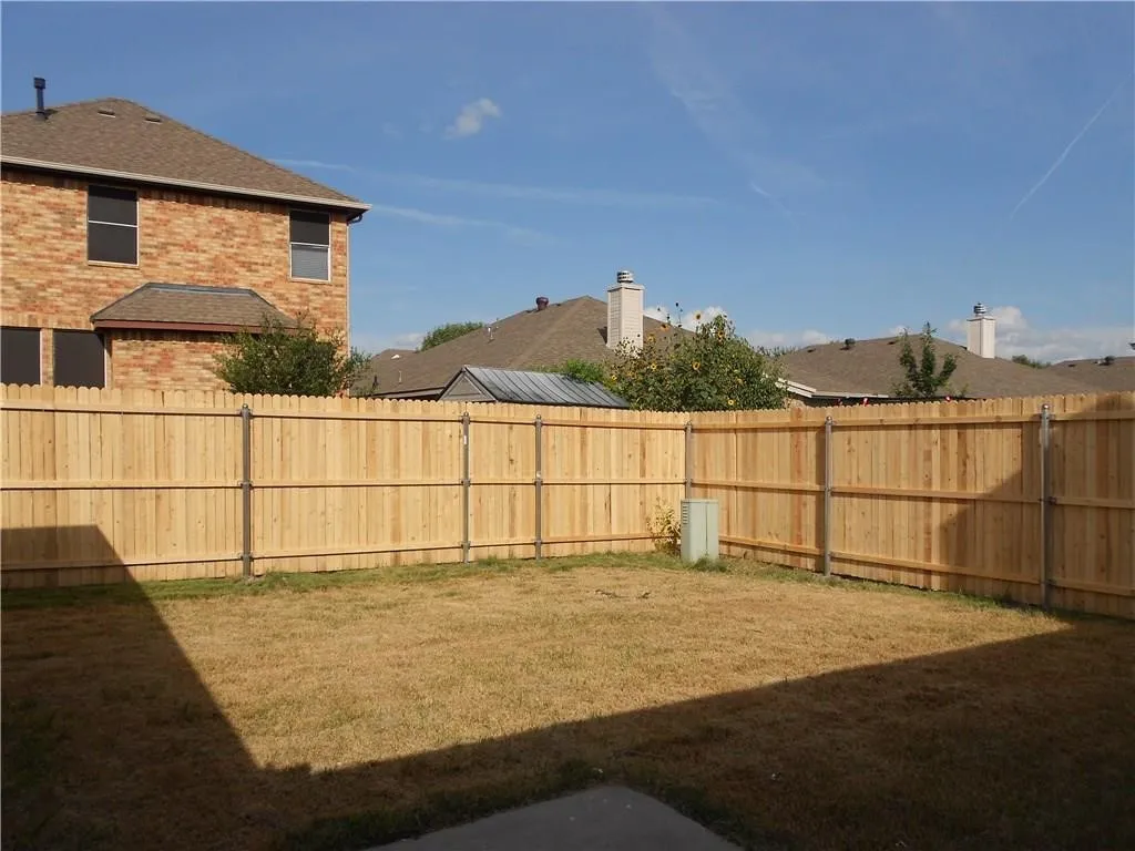 Fenced backyard with a wood privacy fence and a concrete patio section
