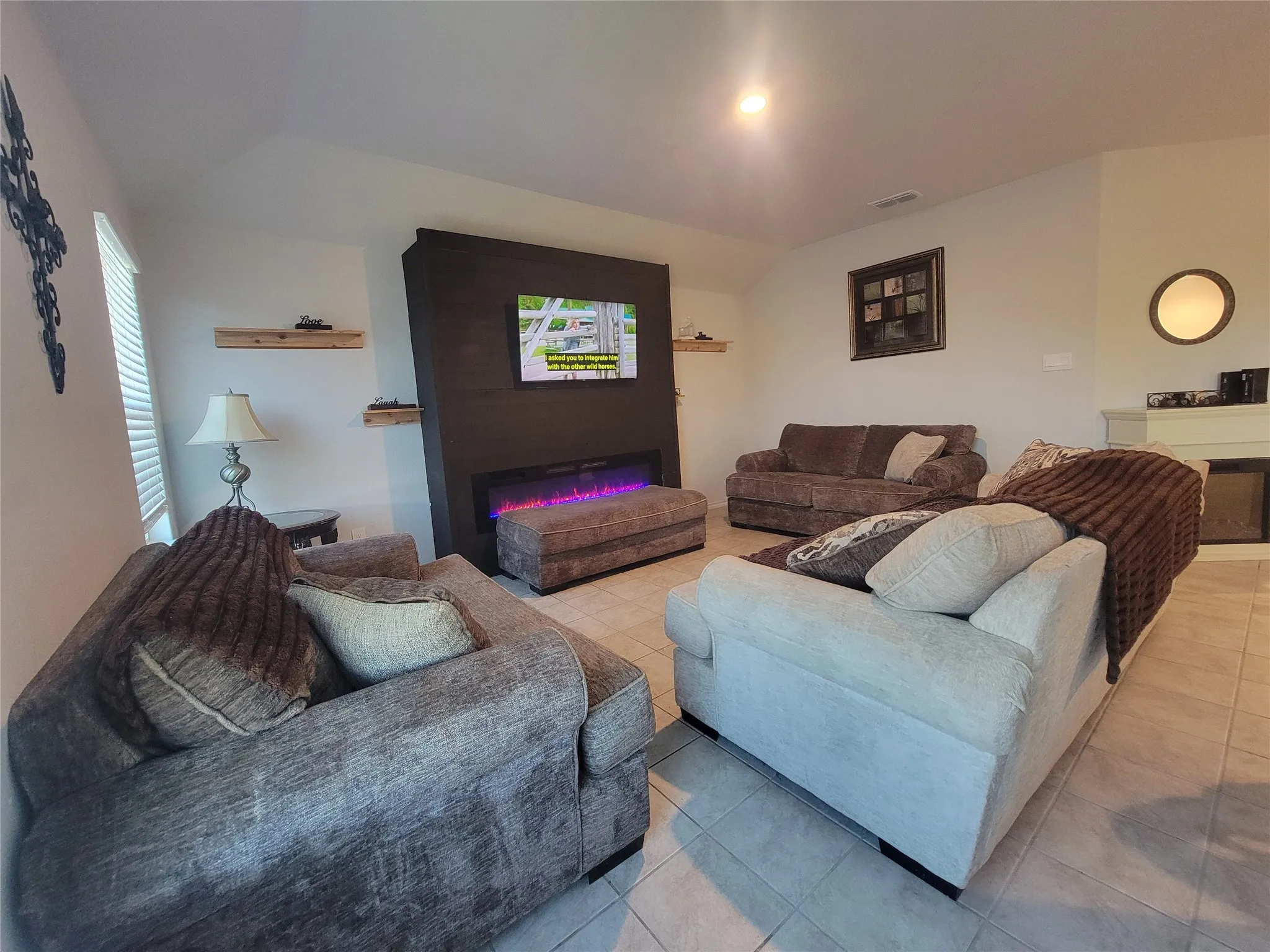 Recessed lighting, tile flooring, built-in media center, wall-mounted display, and floating shelves