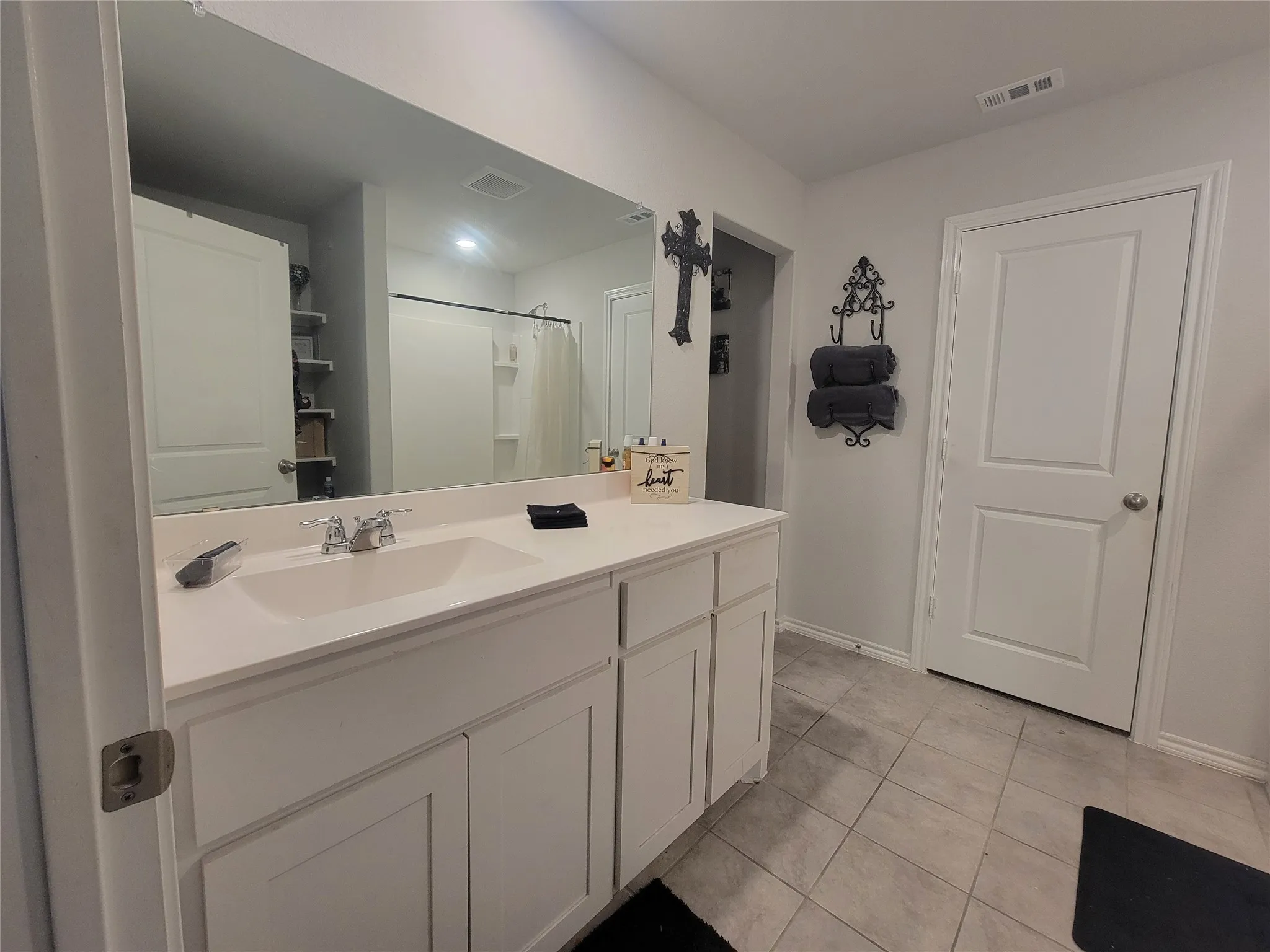 White vanity with dual doors and drawers, undermount sink, and chrome faucet