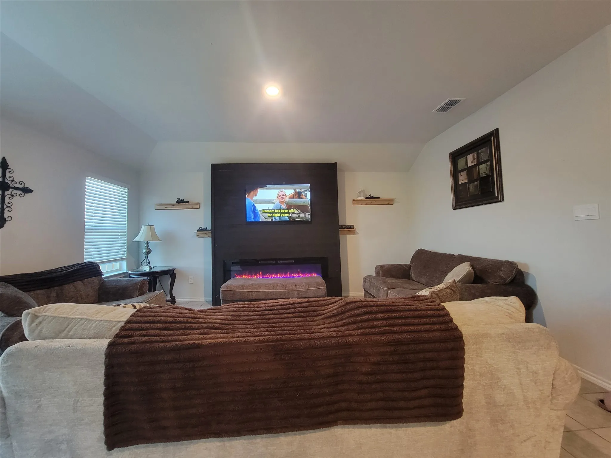Living area featuring a floor-to-ceiling fireplace surround with an integrated electric fireplace