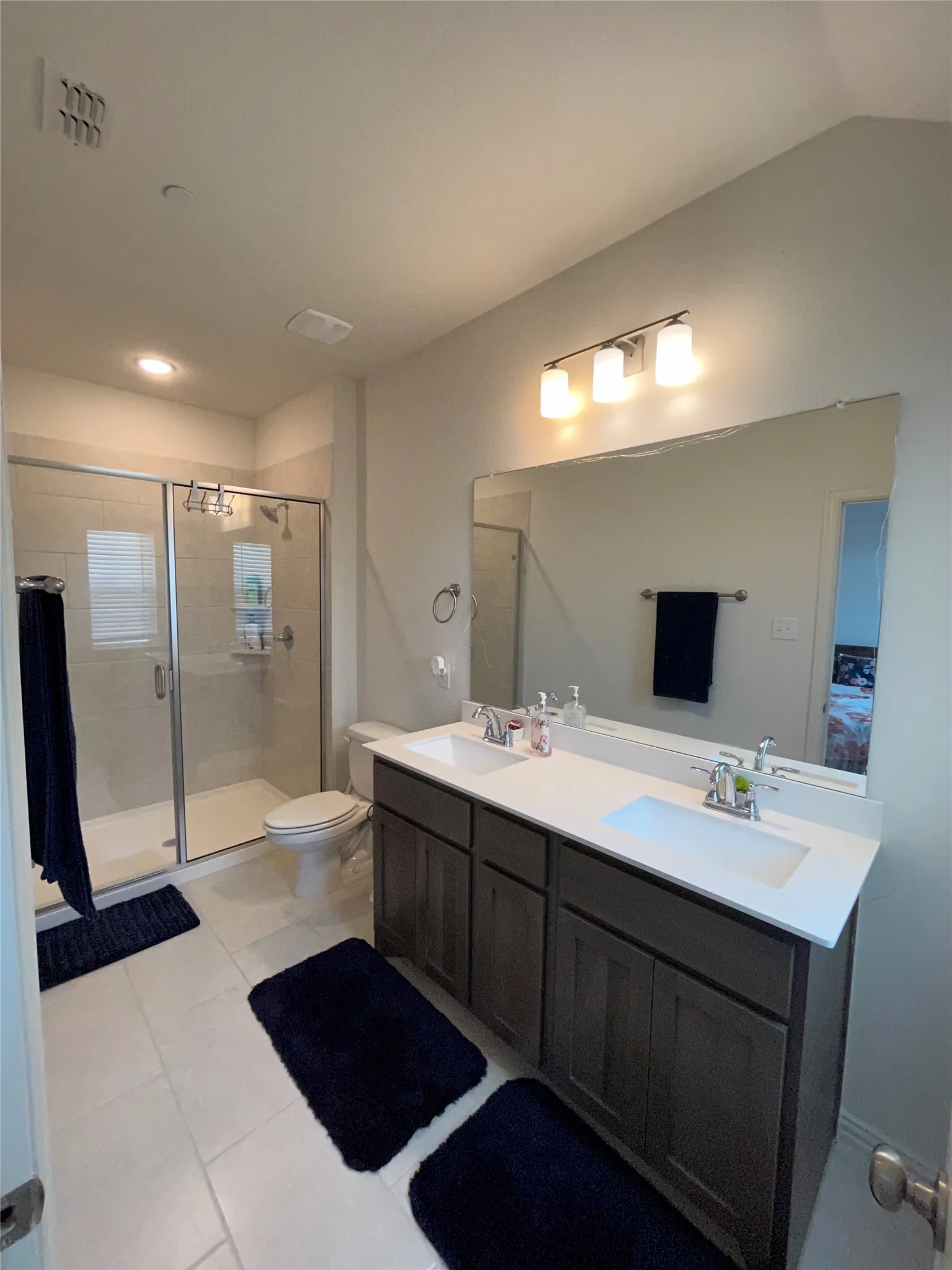 Bathroom with vaulted ceiling, dual vanity, an enclosed oversized shower