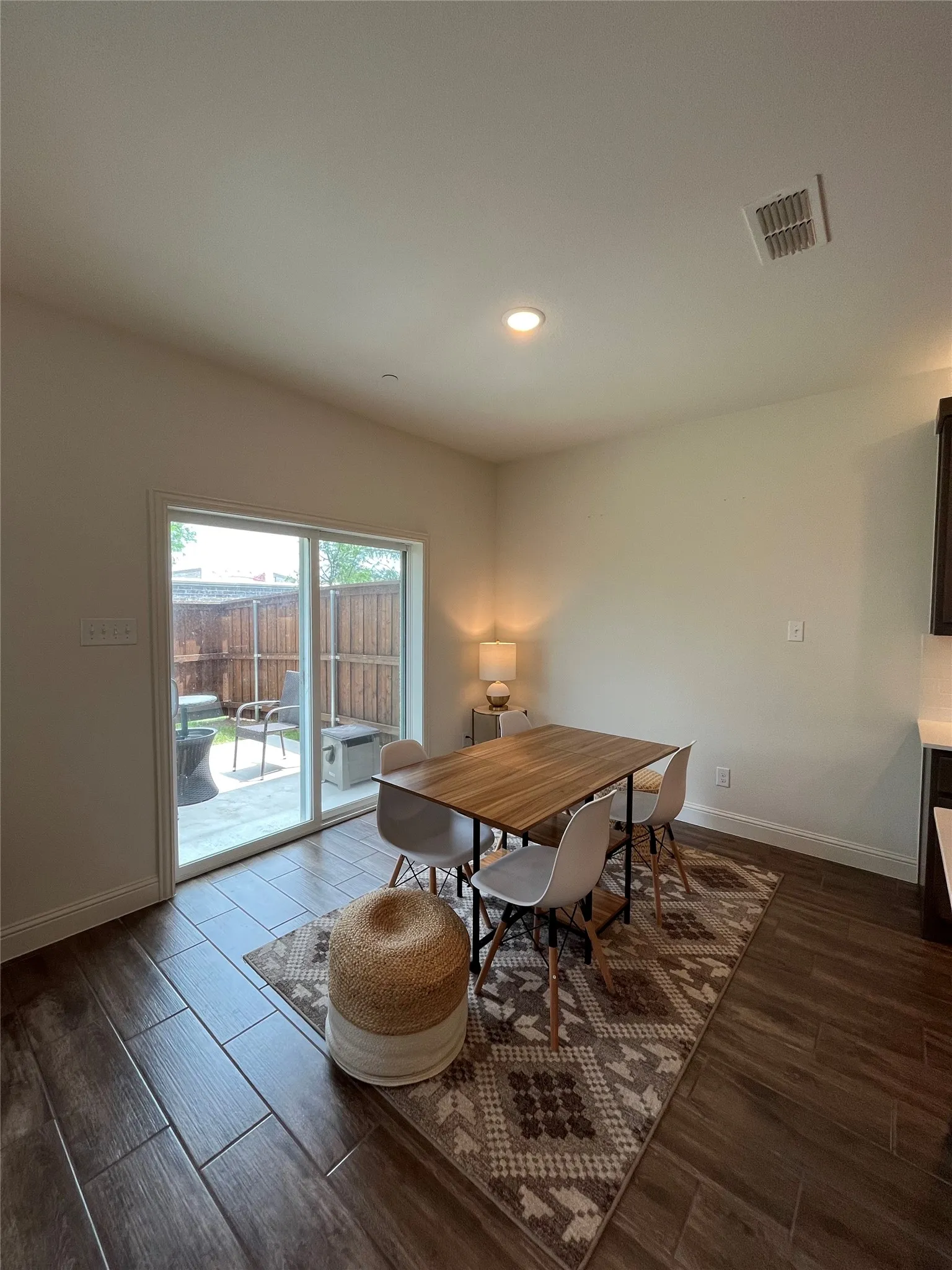 Dining area featuring wood-type flooring opens to a small yard and patio!
