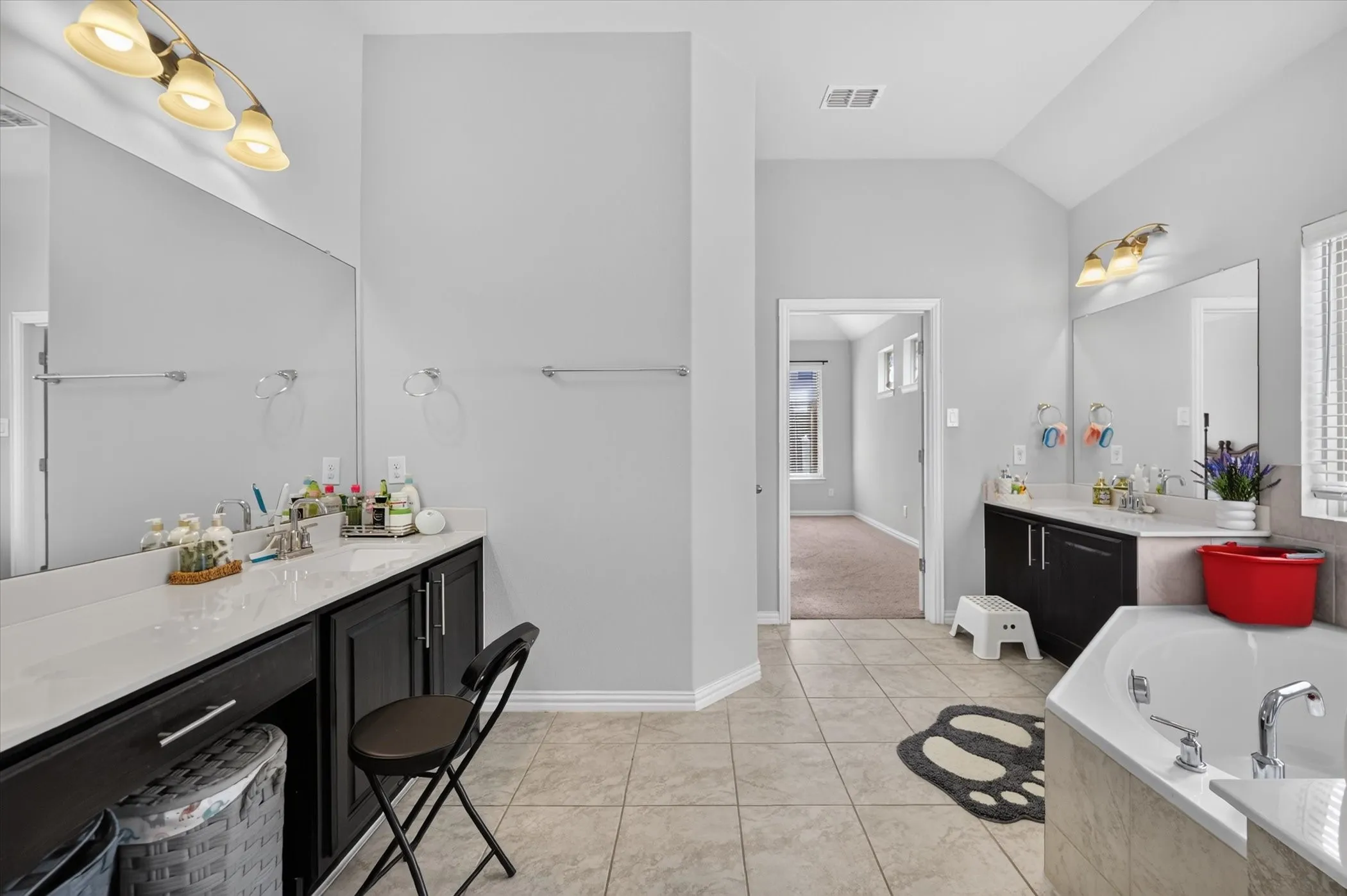 Dual vanity with dark wood-finish cabinetry and light-colored countertops