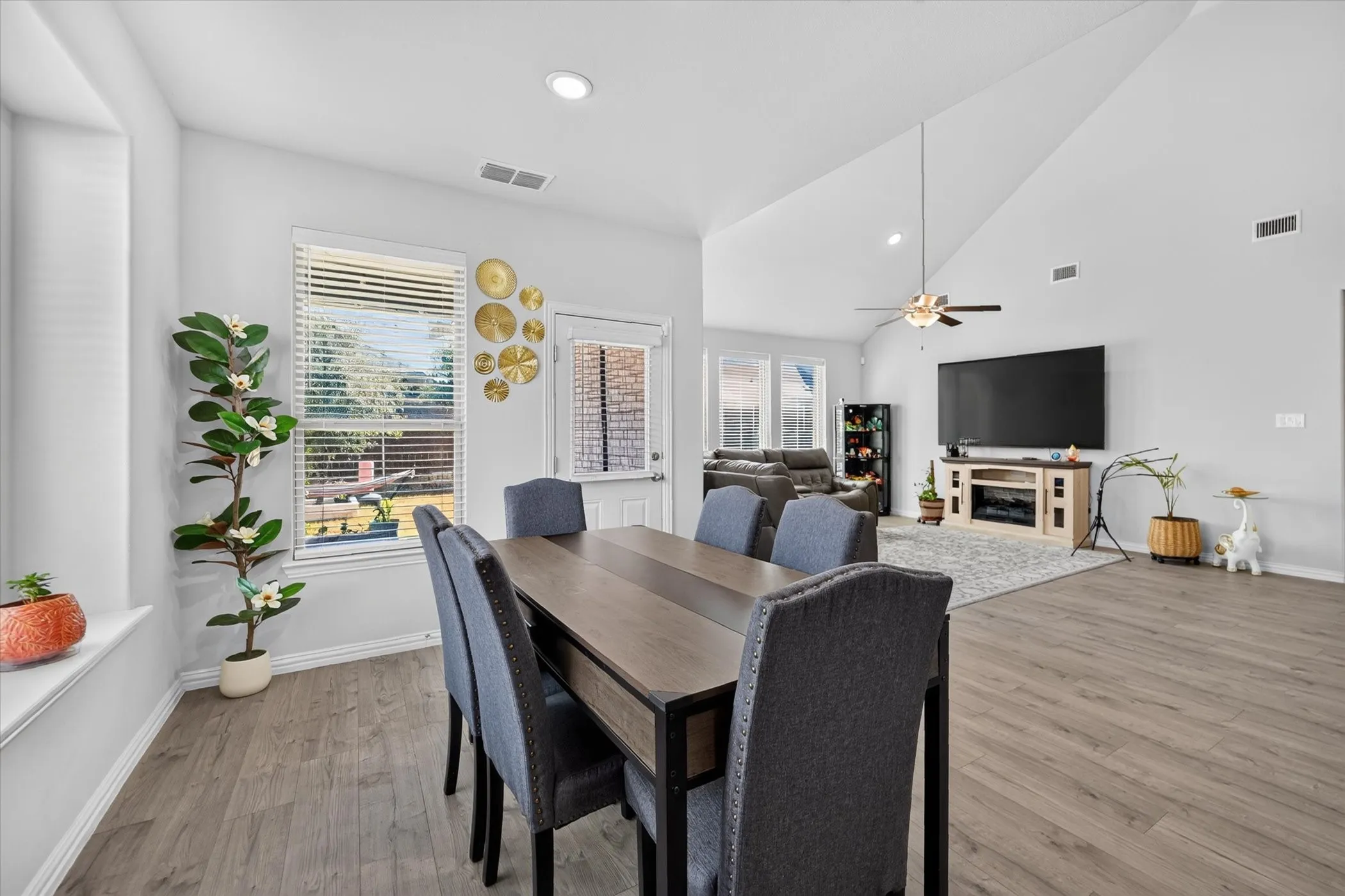Open-concept living area with vaulted ceilings, wood-finish flooring, recessed lighting, and a ceiling fan
