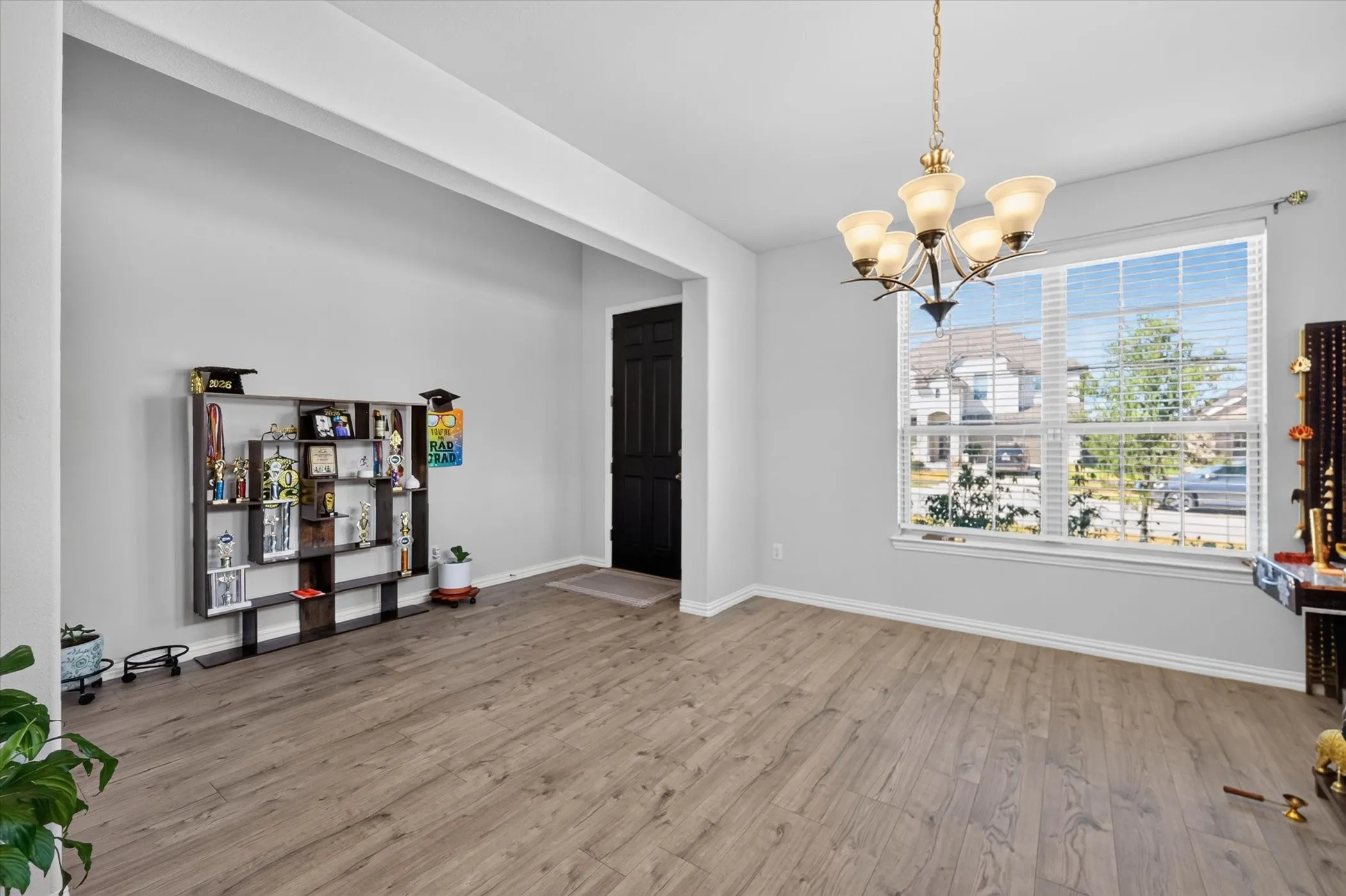 Wood-finish flooring, white walls, and a multi-pane window with blinds