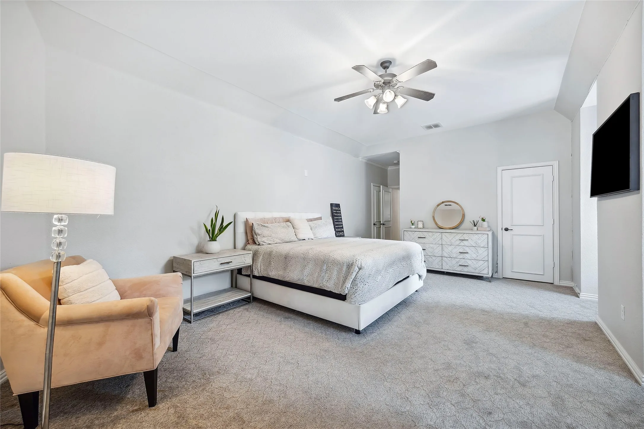 Vaulted ceiling with a contemporary ceiling fan, plush carpet, and a two-panel interior door