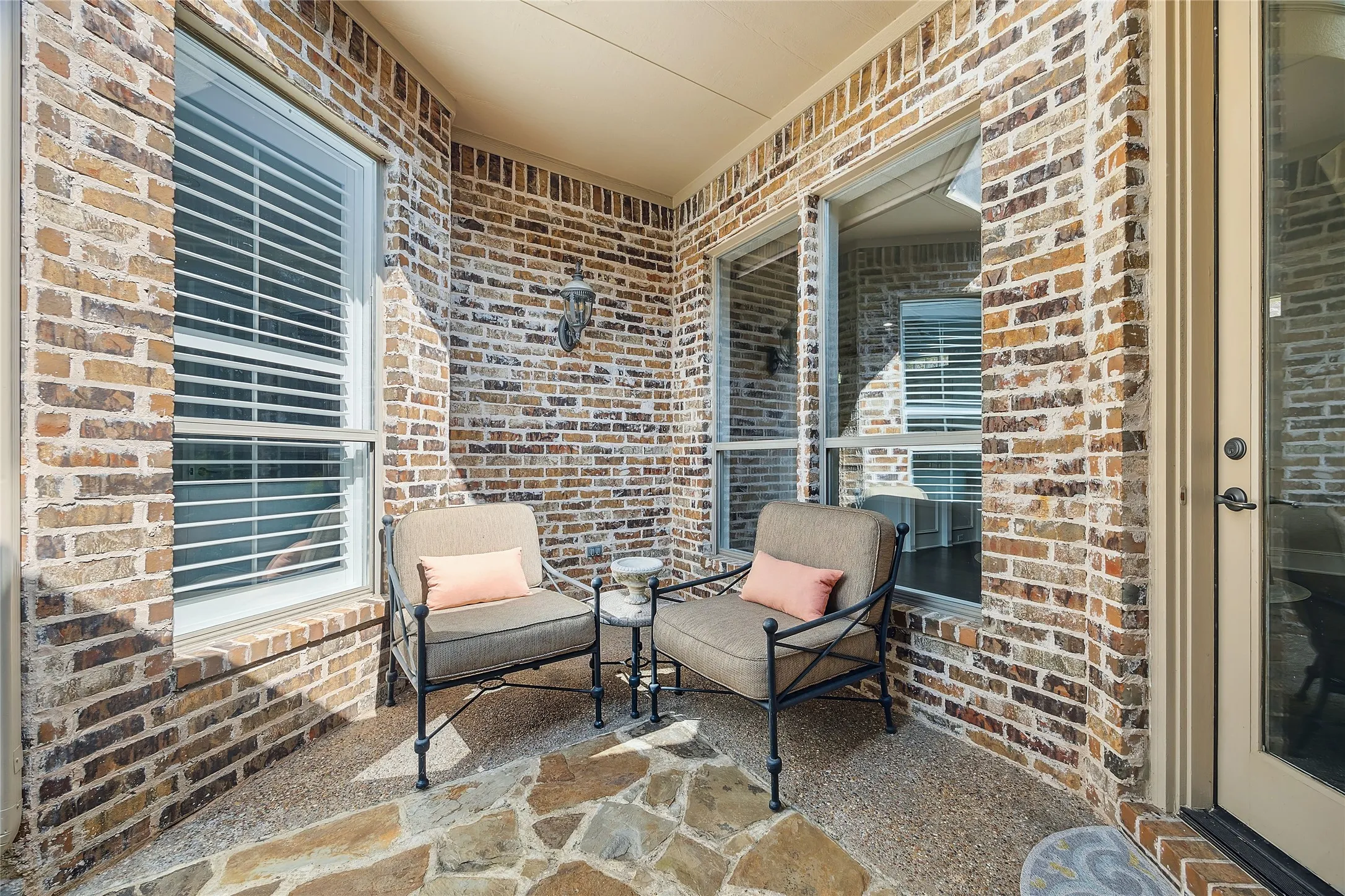 Covered patio featuring brick masonry walls and a flagstone floor