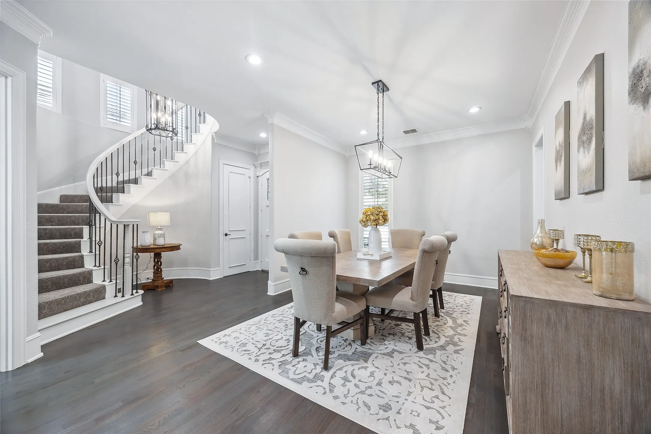 Curved staircase with carpeted treads and wrought iron balusters