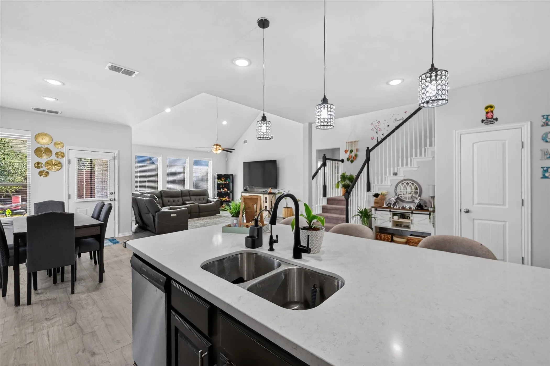 Kitchen island with dual stainless steel sinks, a black gooseneck faucet, and integrated dishwasher
