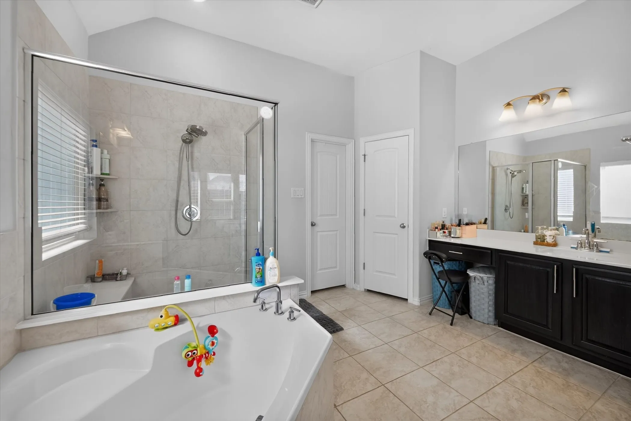Glass-enclosed shower with tiled walls and a built-in bench