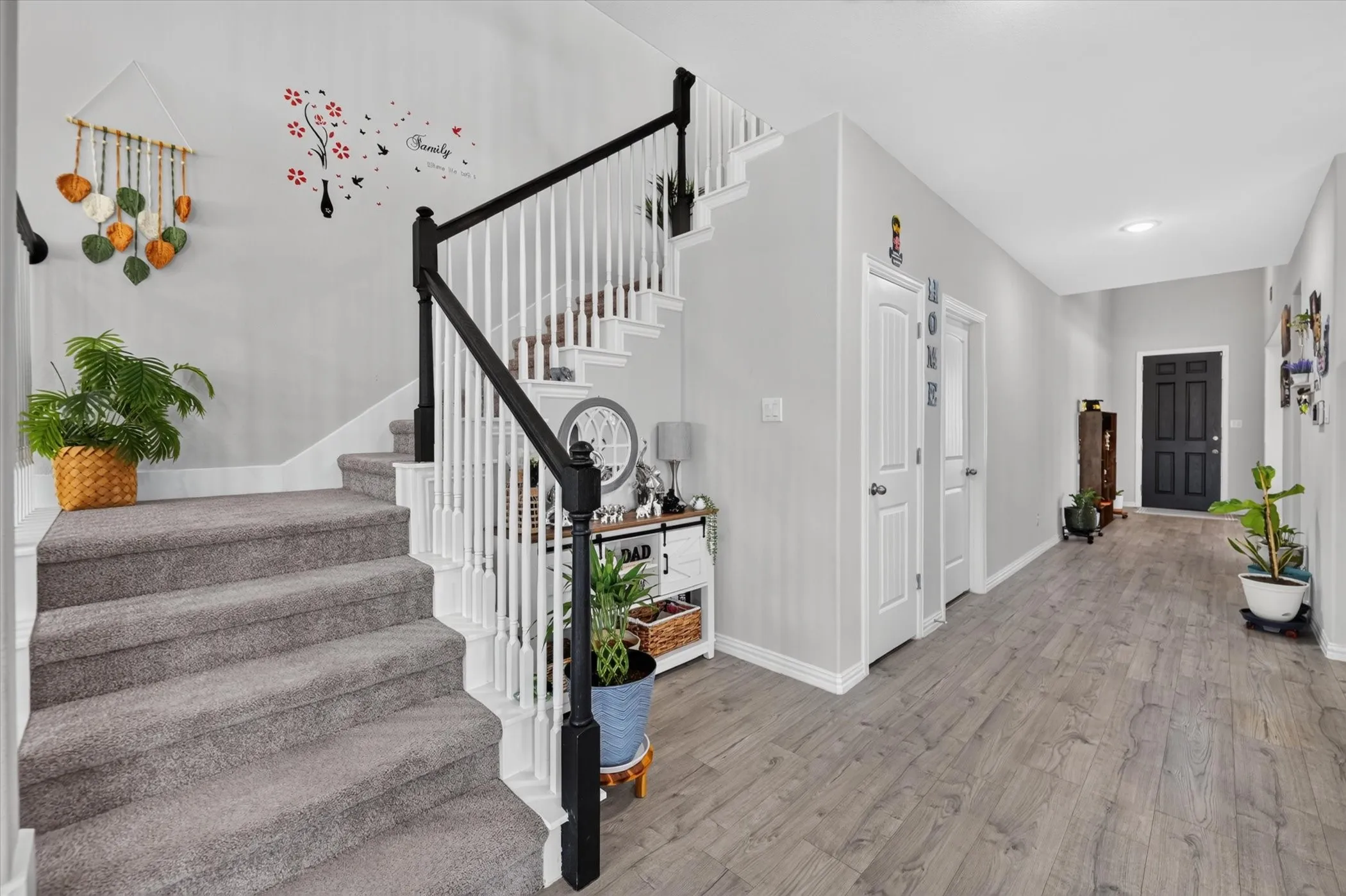 Entryway featuring wood-finish flooring and a staircase with carpeting