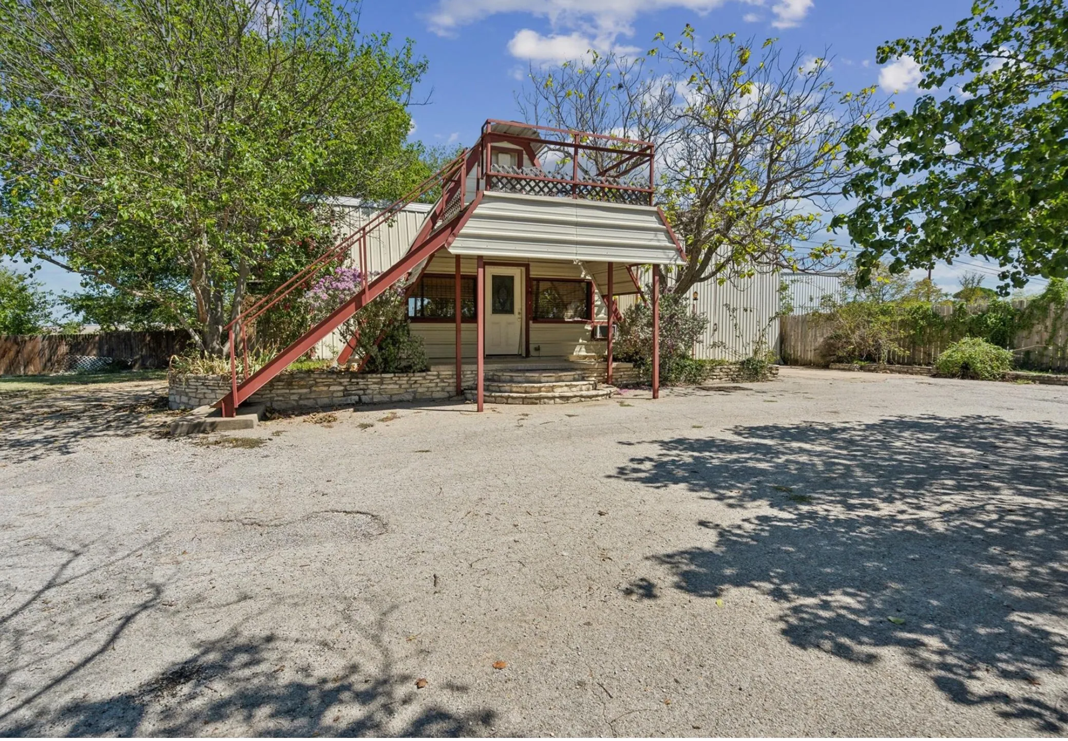 Rear view of house featuring stairs and fence