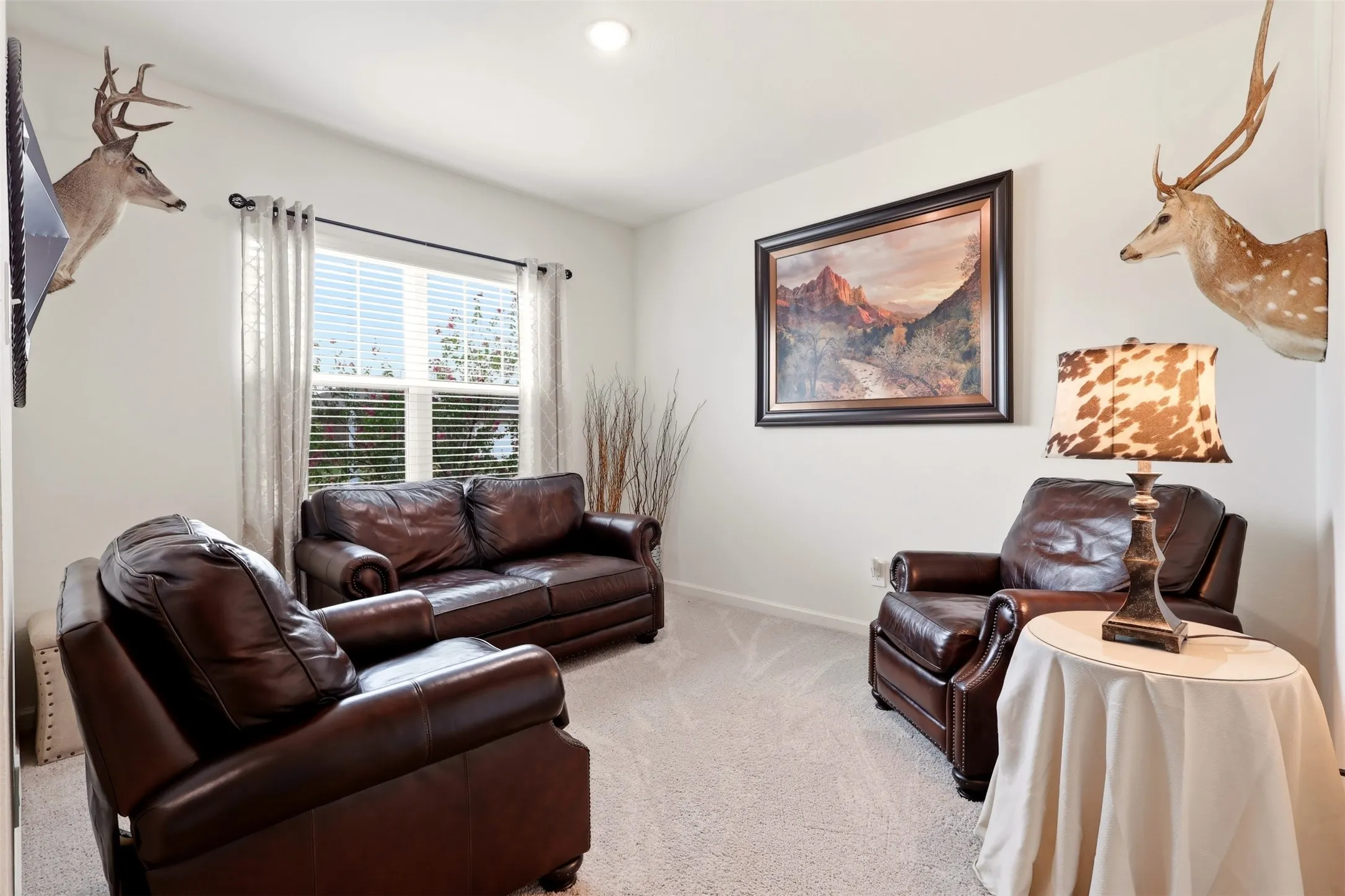 Recessed lighting illuminates a space featuring a window with blinds, and carpet flooring