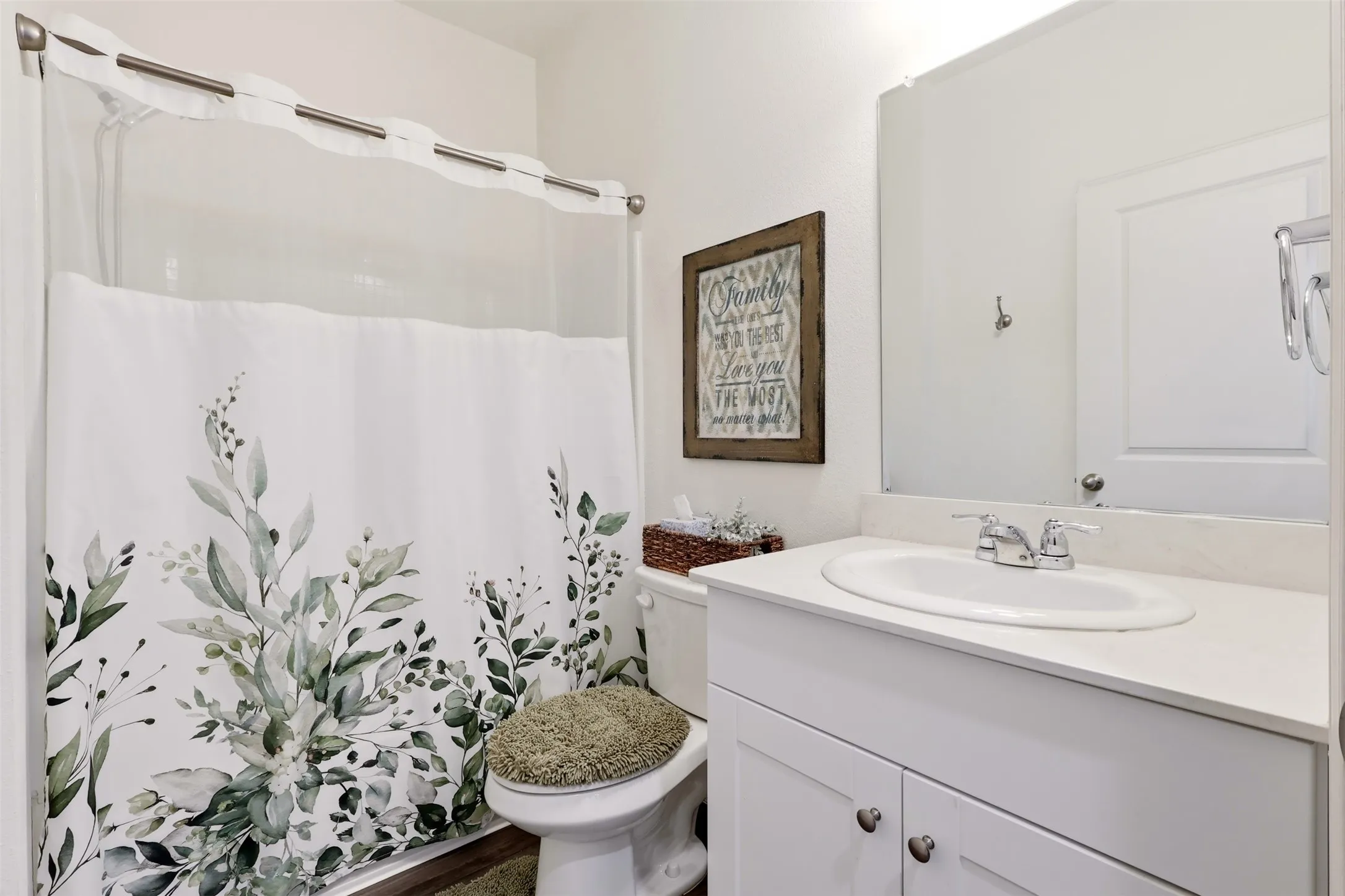Bathroom featuring a white vanity with an undermount sink, a large wall-mounted mirror, and a shower-over-tub combination