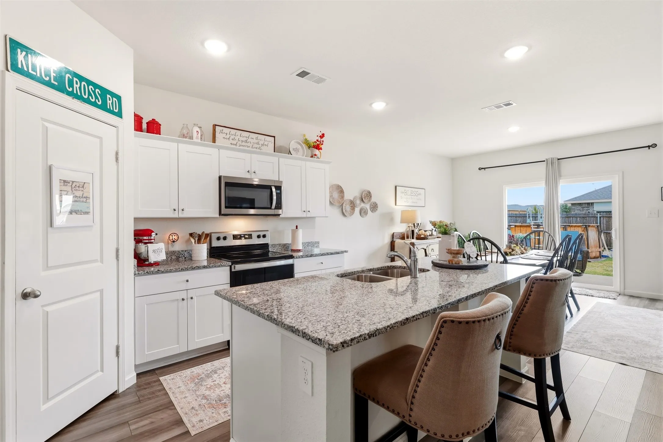 Kitchen featuring white cabinetry, stainless steel appliances, a kitchen island with sink, and wood-finish flooring