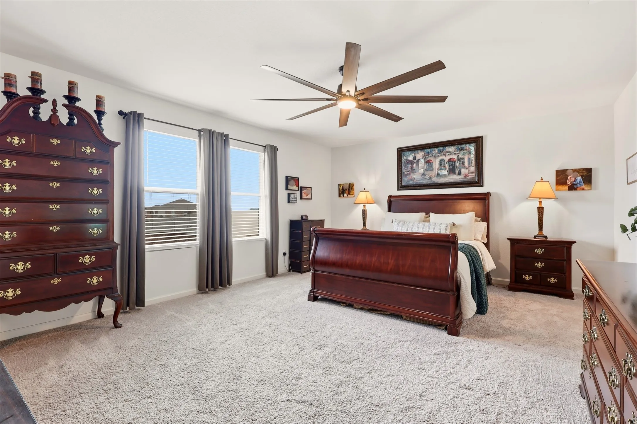  light-colored carpeting, multiple windows with blinds, a ceiling fan with integrated lighting, and neutral wall tones