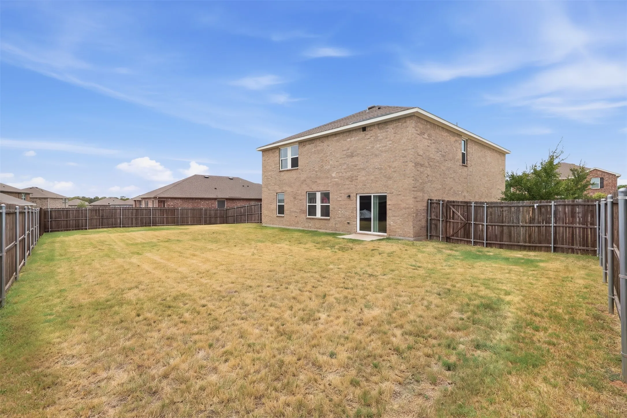 fenced backyard with mature lawn and wooden privacy fencing
