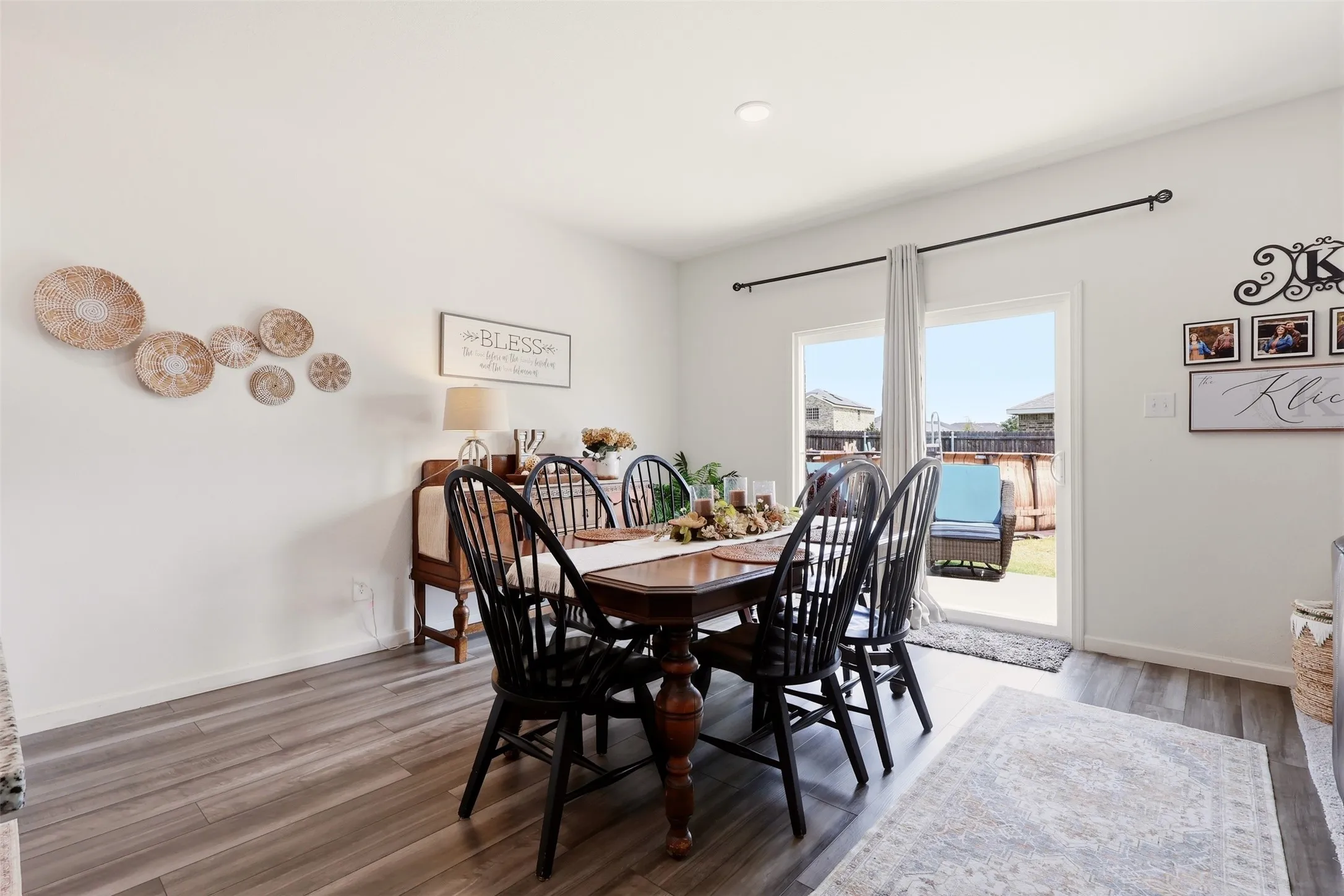 Wood-finish flooring, recessed ceiling lighting, and a sliding glass door providing outdoor access