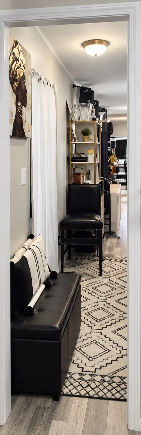 Wood-finish flooring with a neutral paint palette and crown molding next to laundry room