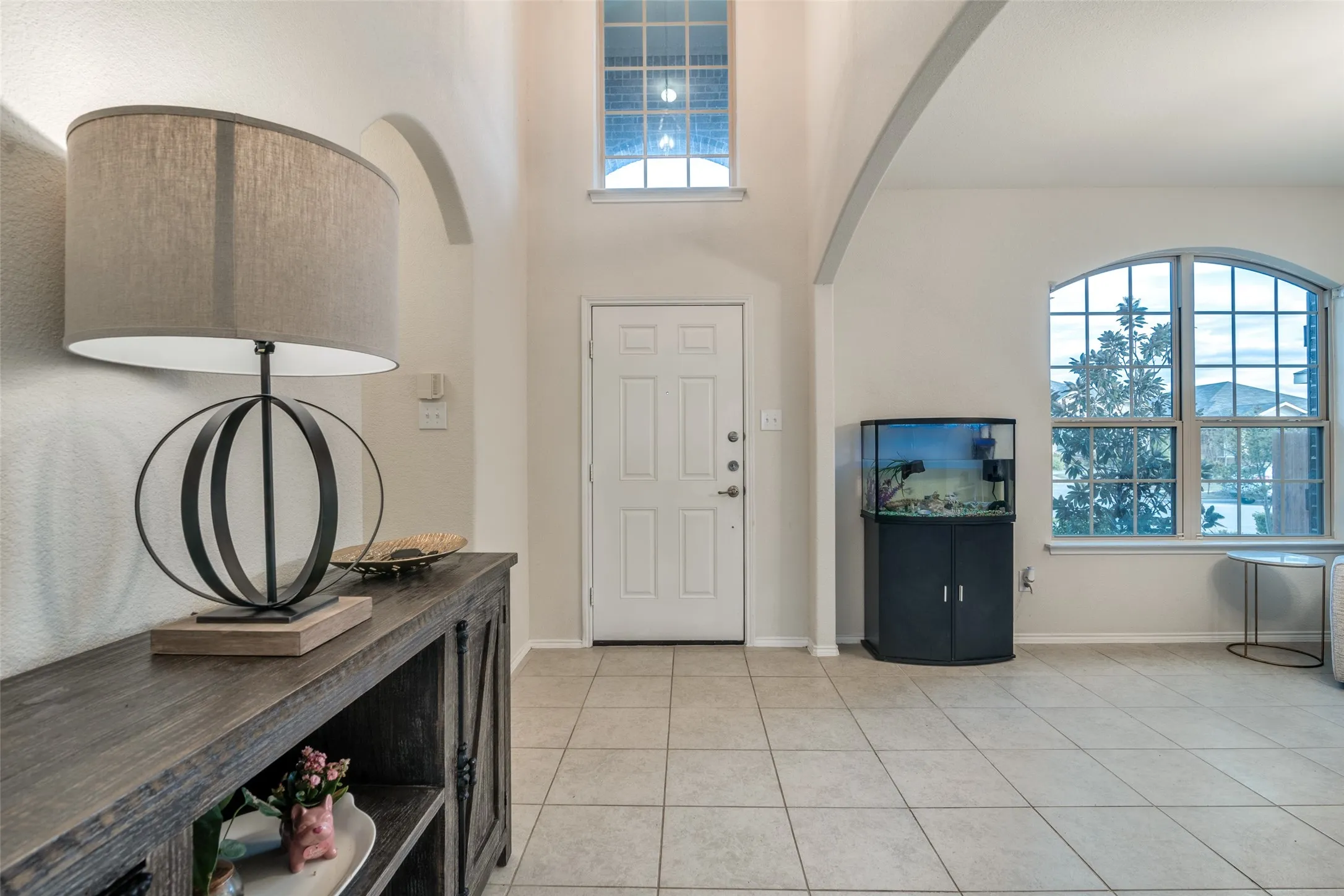Tile flooring, arched doorways, transom window, and an arched window