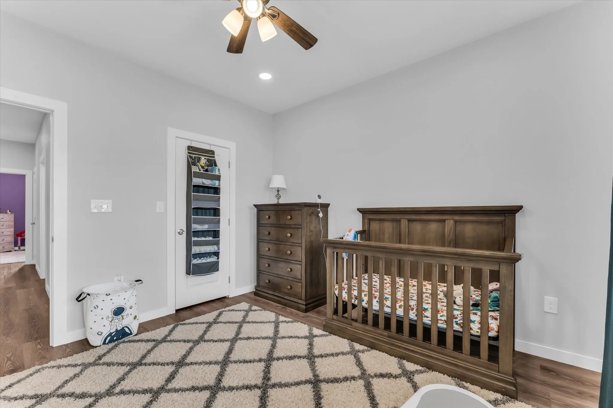 Ceiling fan with integrated lighting, recessed ceiling light, wood-finish flooring, white trim, and light gray wall paint