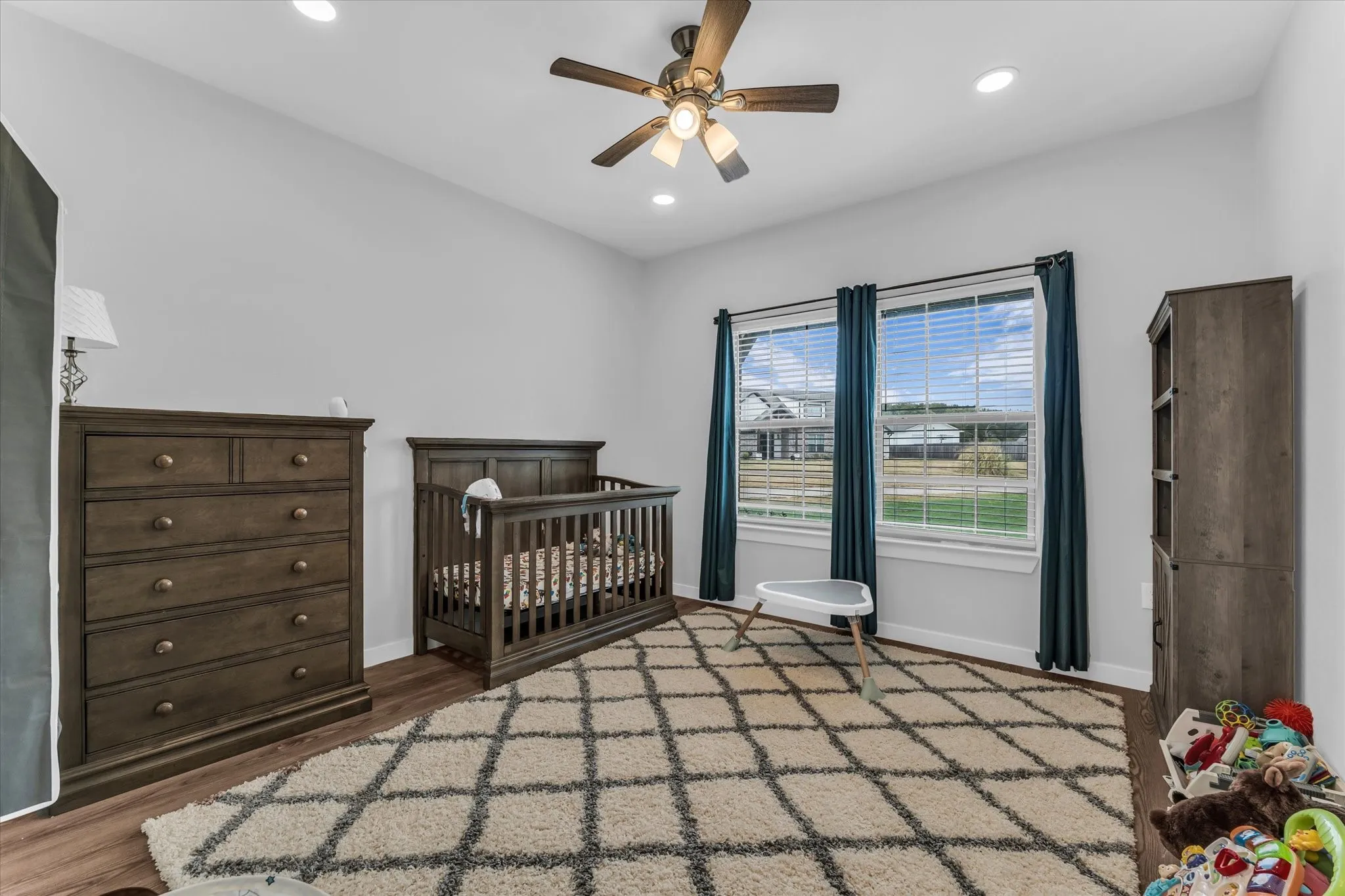 Angled ceiling, wood-finish flooring, recessed lighting, ceiling fan light fixture, dual window installation