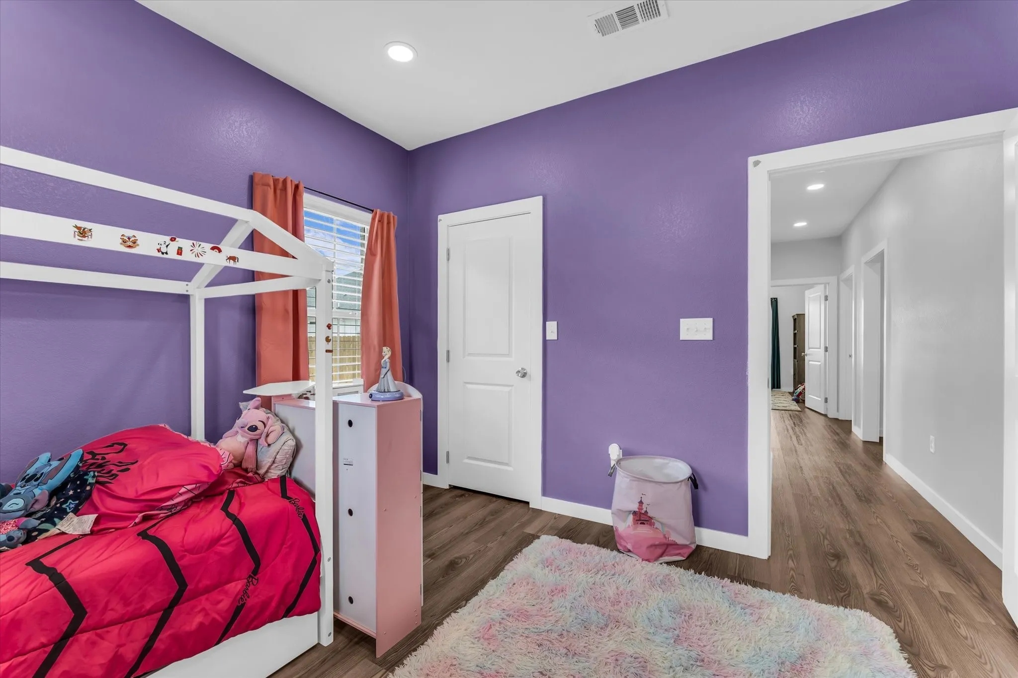 Recessed lighting, wood-finish flooring, white trim, and a white door frame