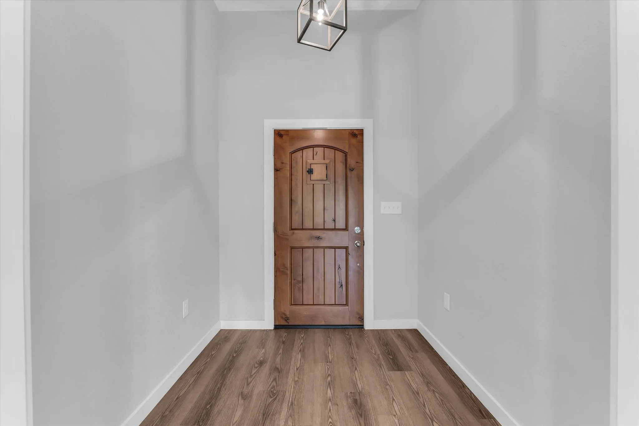 Wood-finish flooring, light gray walls, and a recessed ceiling light fixture