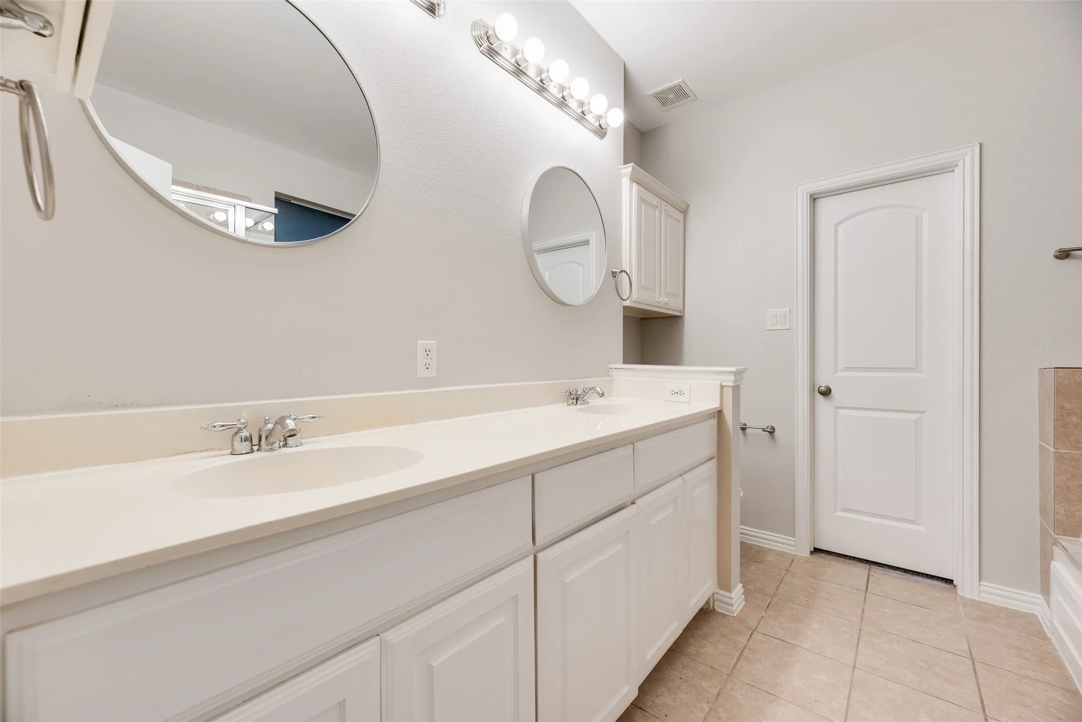Dual vanity with undermount sinks, chrome fixtures, and a light-toned countertop
