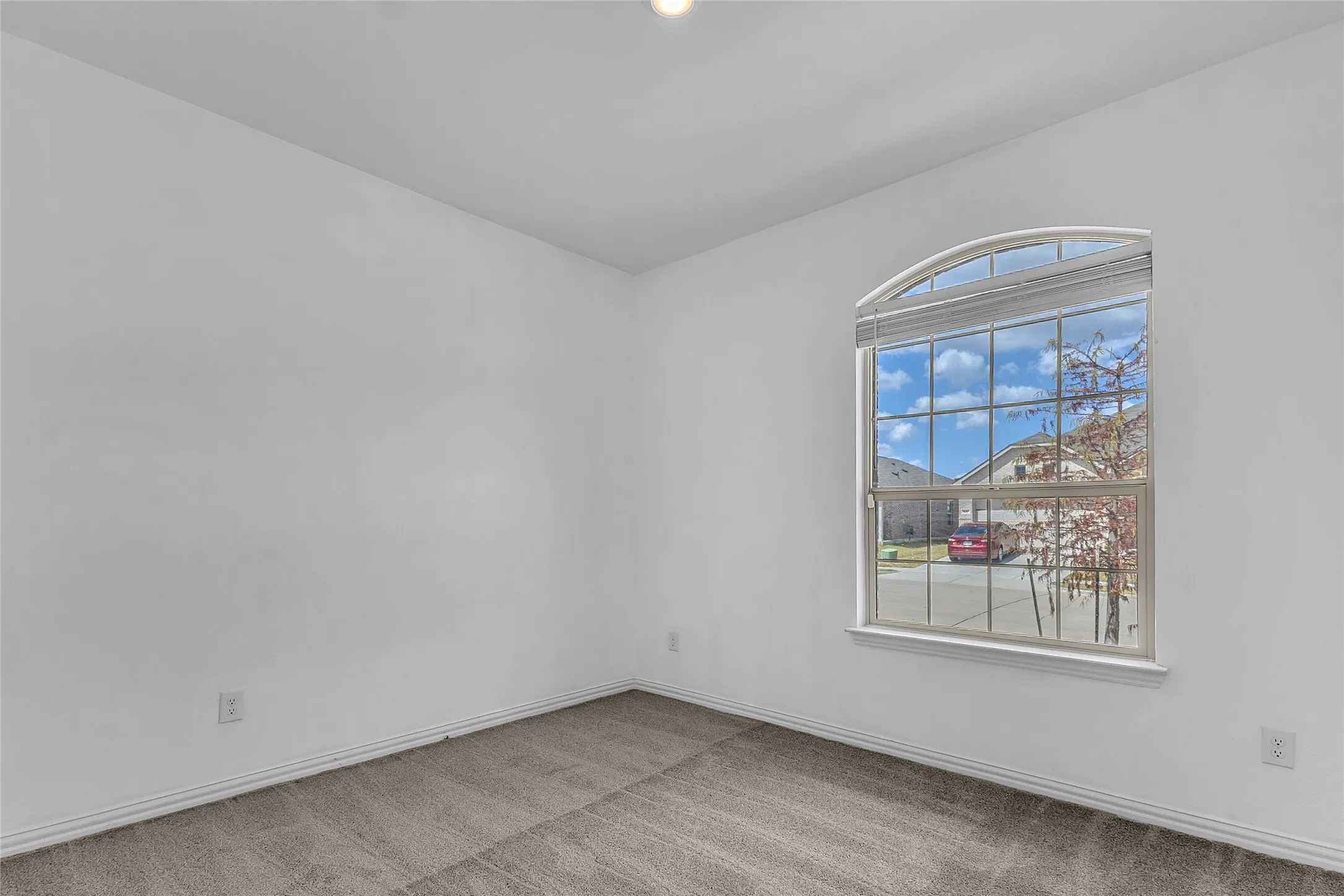 Front-facing secondary bedroom with an arched-top window and carpet in Walden Pond East