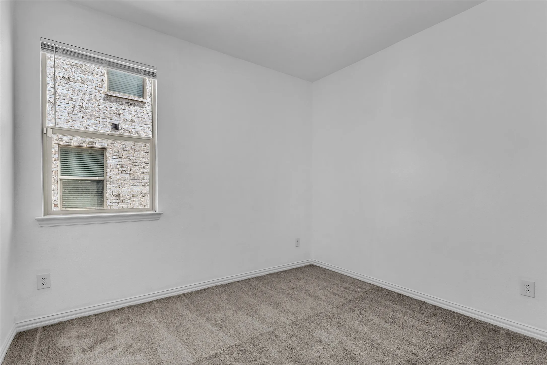Secondary bedroom with carpet and a single window with blinds in this four-bedroom Forney single-story home
