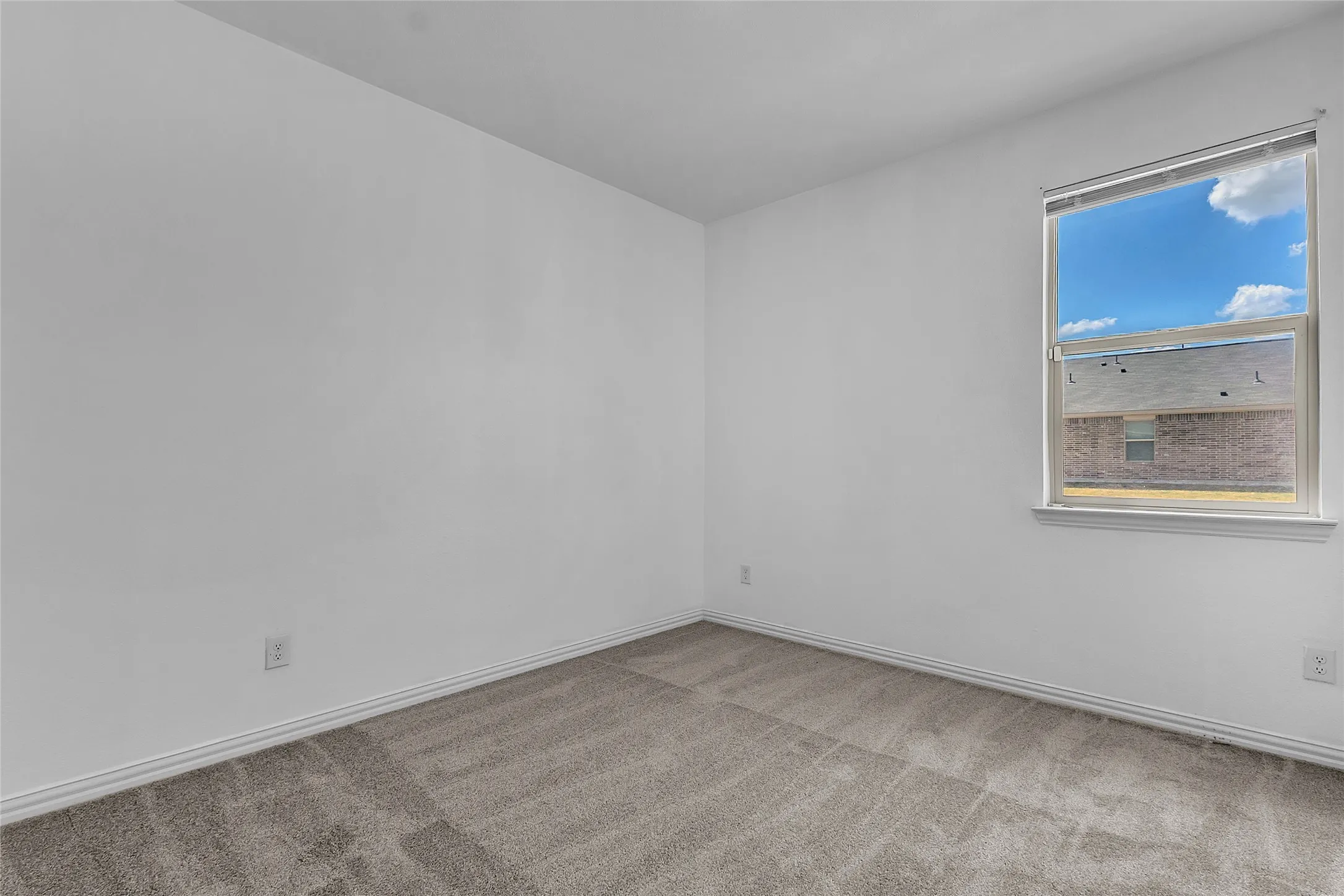 Secondary bedroom with carpet, a window with blinds, and neutral white walls and trim