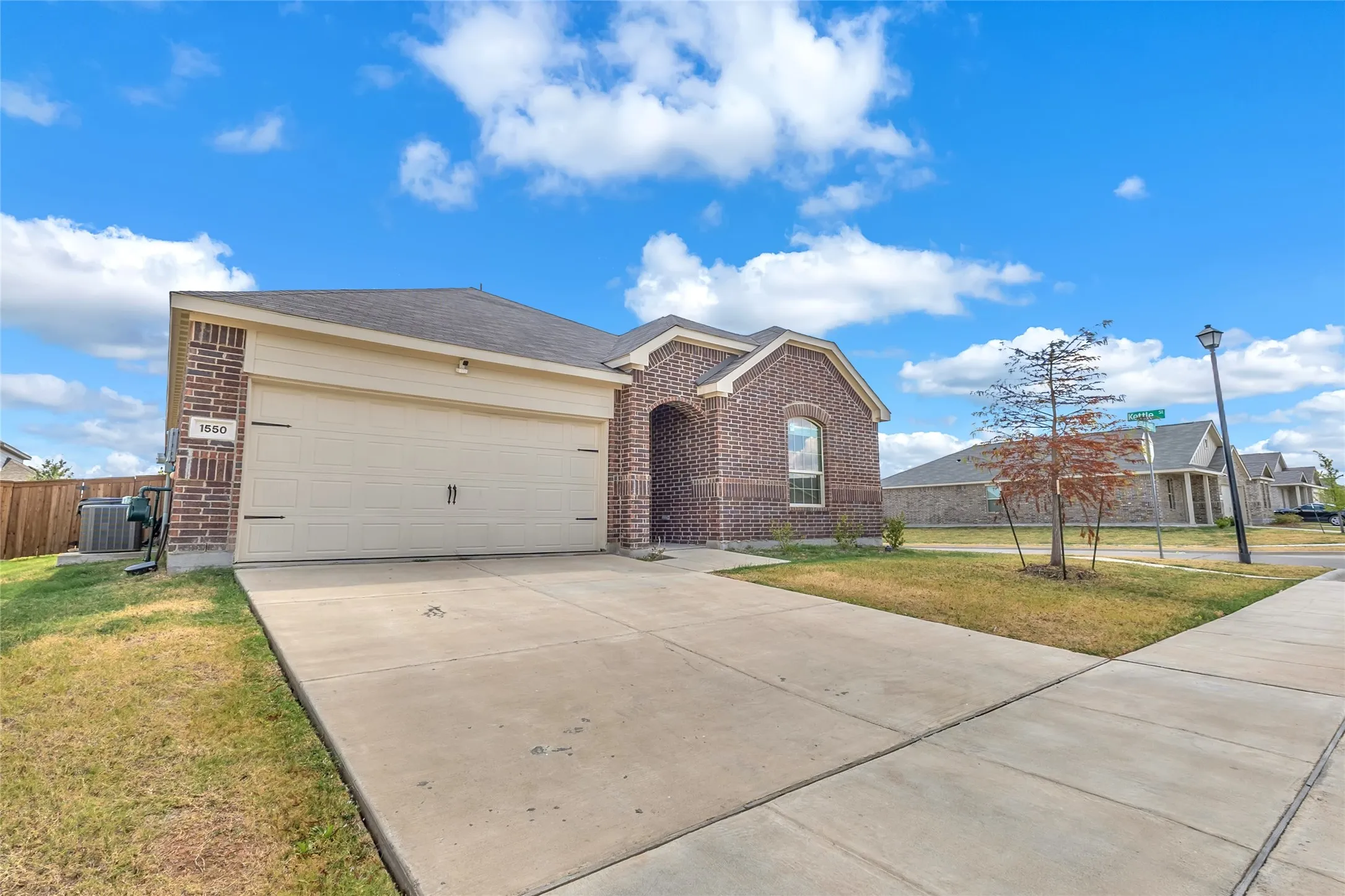 Front of this Forney TX home on a corner lot, with a two-car garage and wide driveway