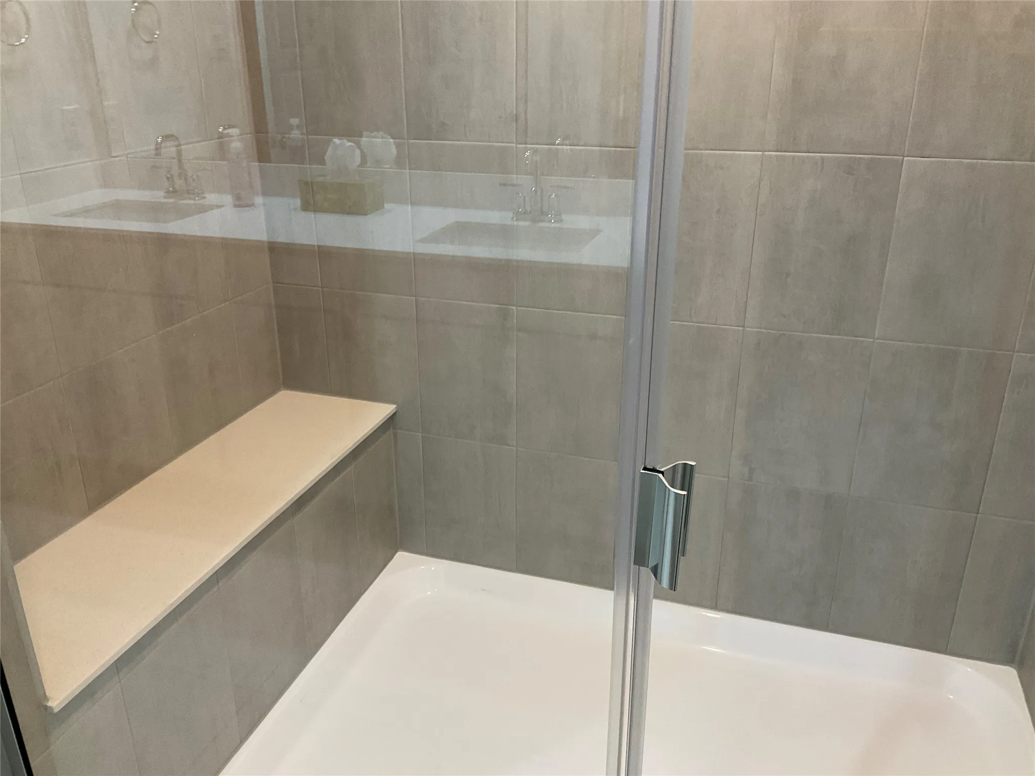 Bathroom featuring a tile shower and a sink