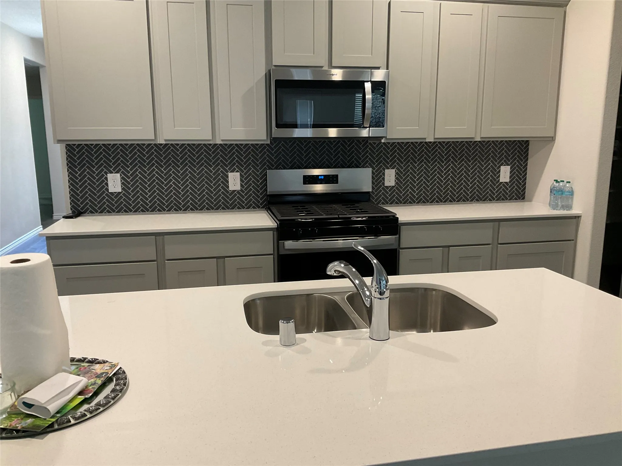 Kitchen featuring backsplash, gray cabinets, and appliances with stainless steel finishes