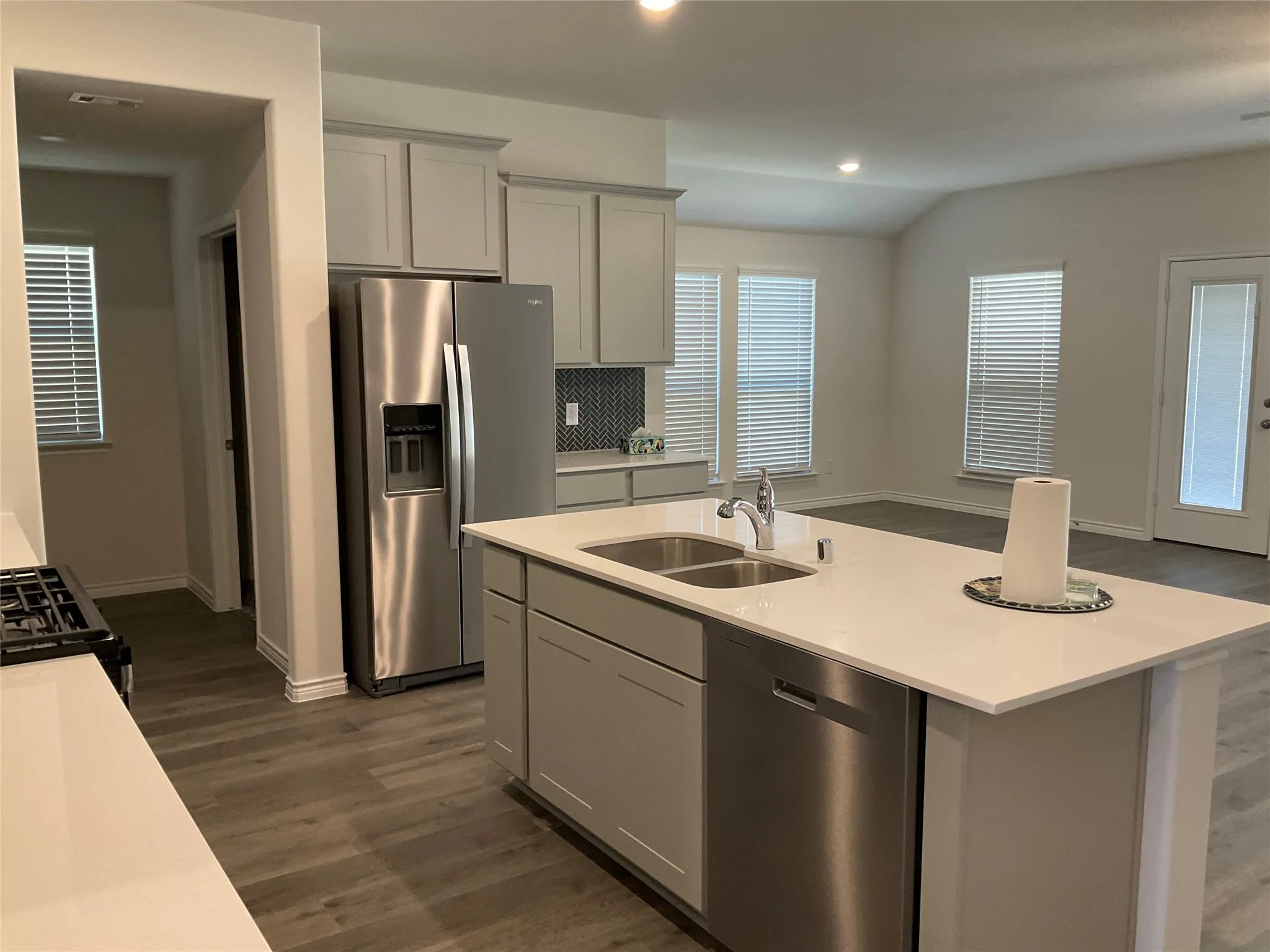 Kitchen with a sink, light countertops, and stainless steel appliances