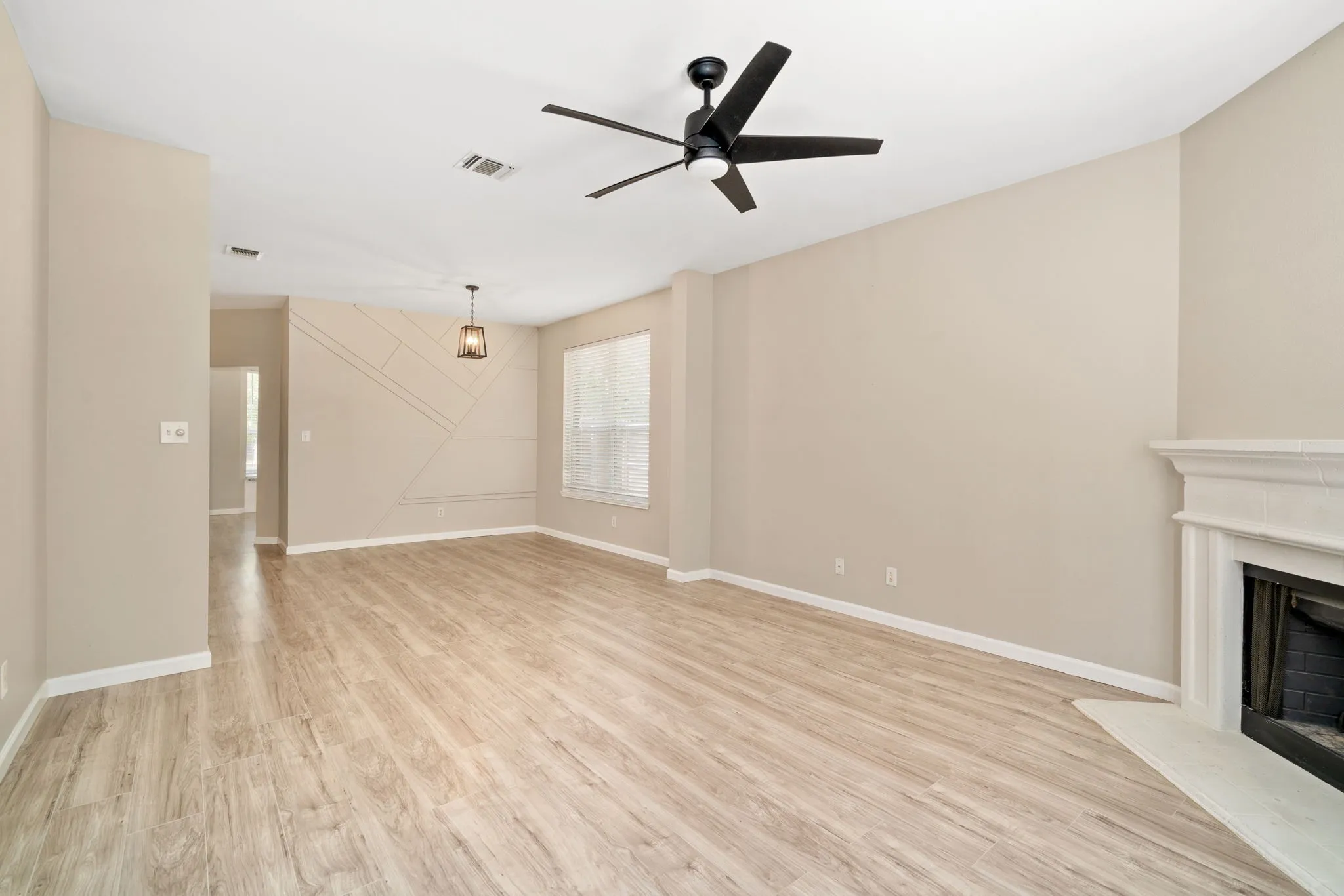 The spacious living area boasts neutral colors and laminate flooring.