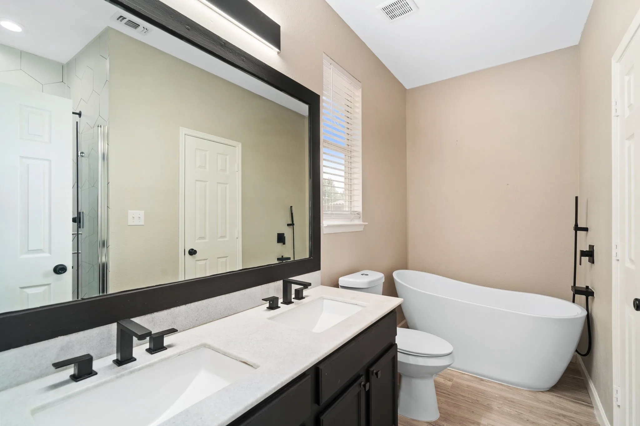 The primary suite boasts an ensuite bath with a stand alone tub and granite counters.