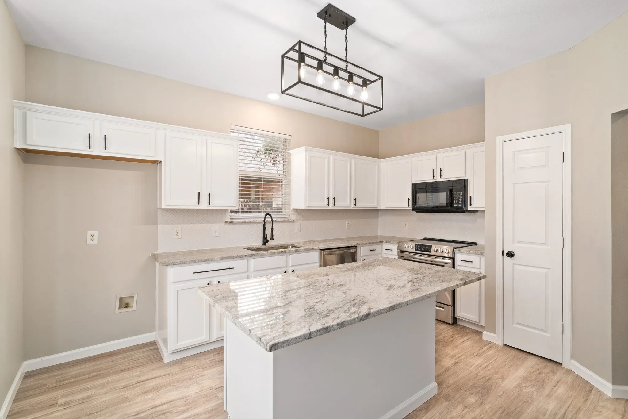 The kitchen boasts updated lighting and windows which allow for plenty of natural light.