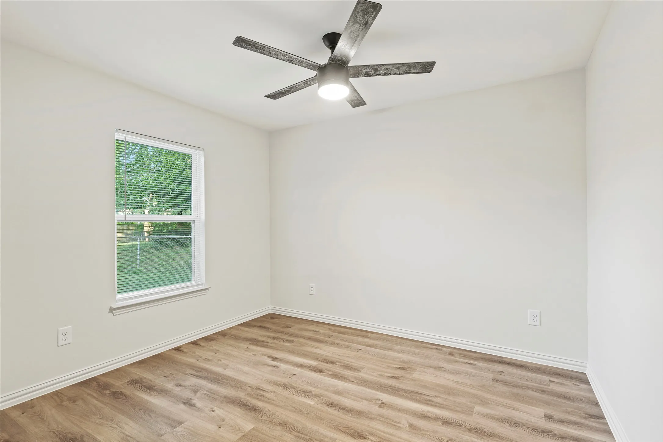 Unfurnished room with light wood-style flooring, baseboards, and ceiling fan