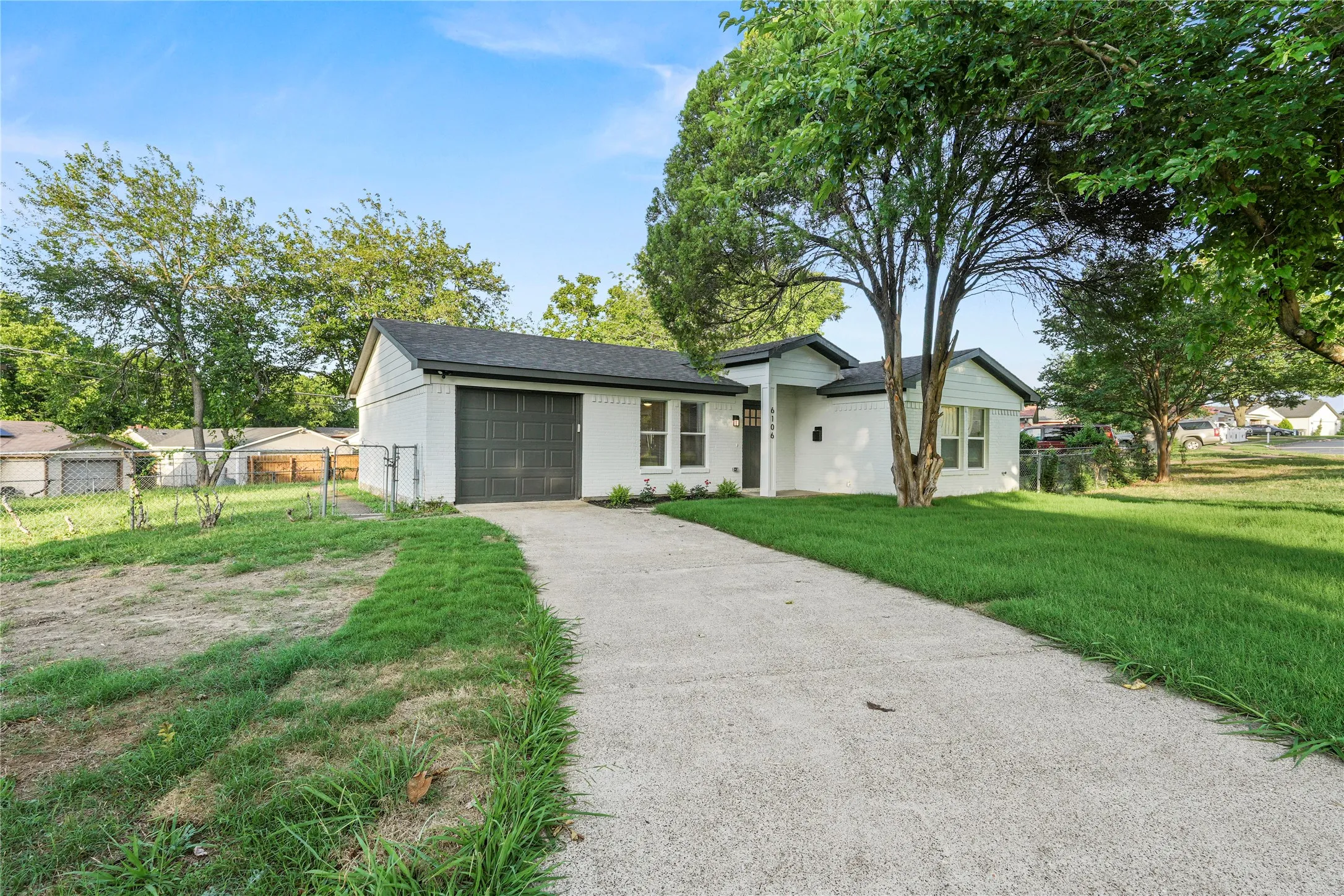 View of front facade featuring an attached garage, asphalt driveway, and a shingled roof